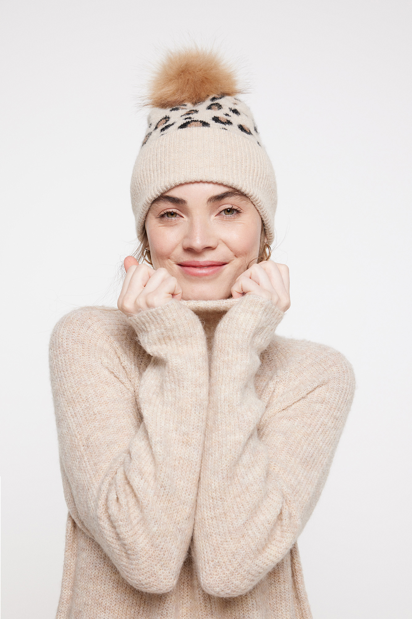 Gorro de tricô com estampa. Possui pompom e aba dobrada.