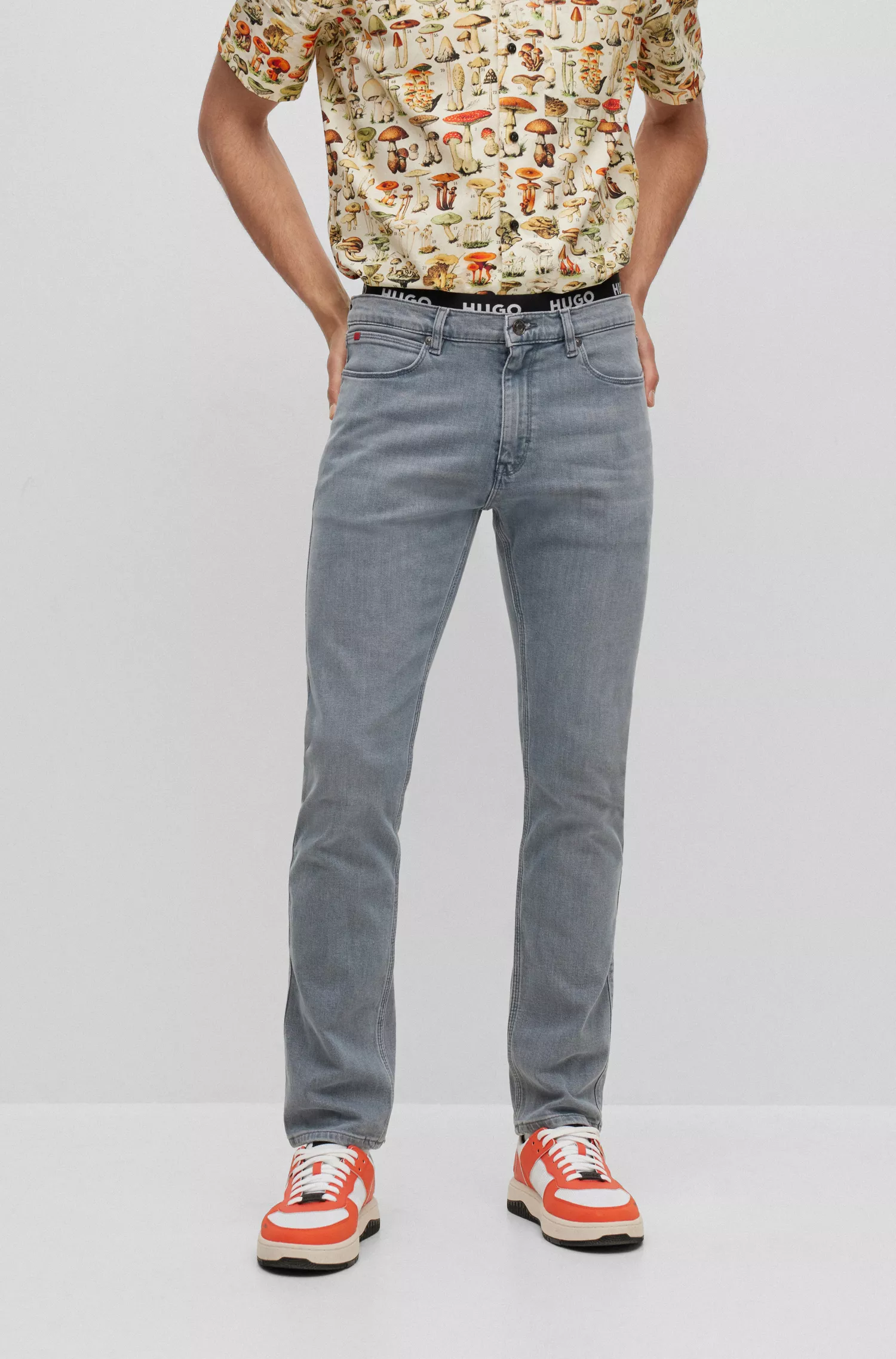 Calça jeans HUGO vermelha, corte slim, em denim cinza com elasticidade para maior conforto.