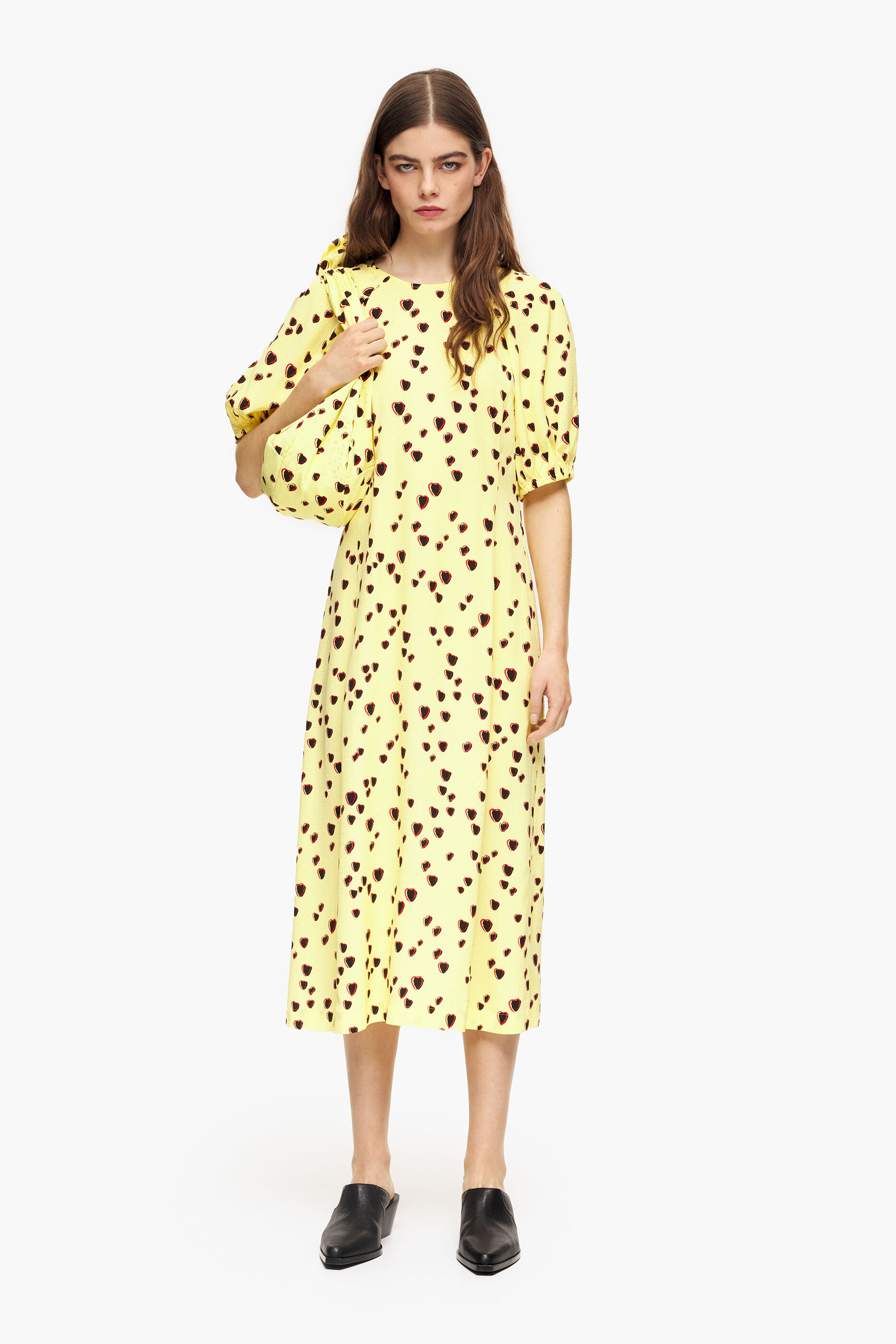 Vestido midi evasê com estampa de pequenos corações em amarelo.