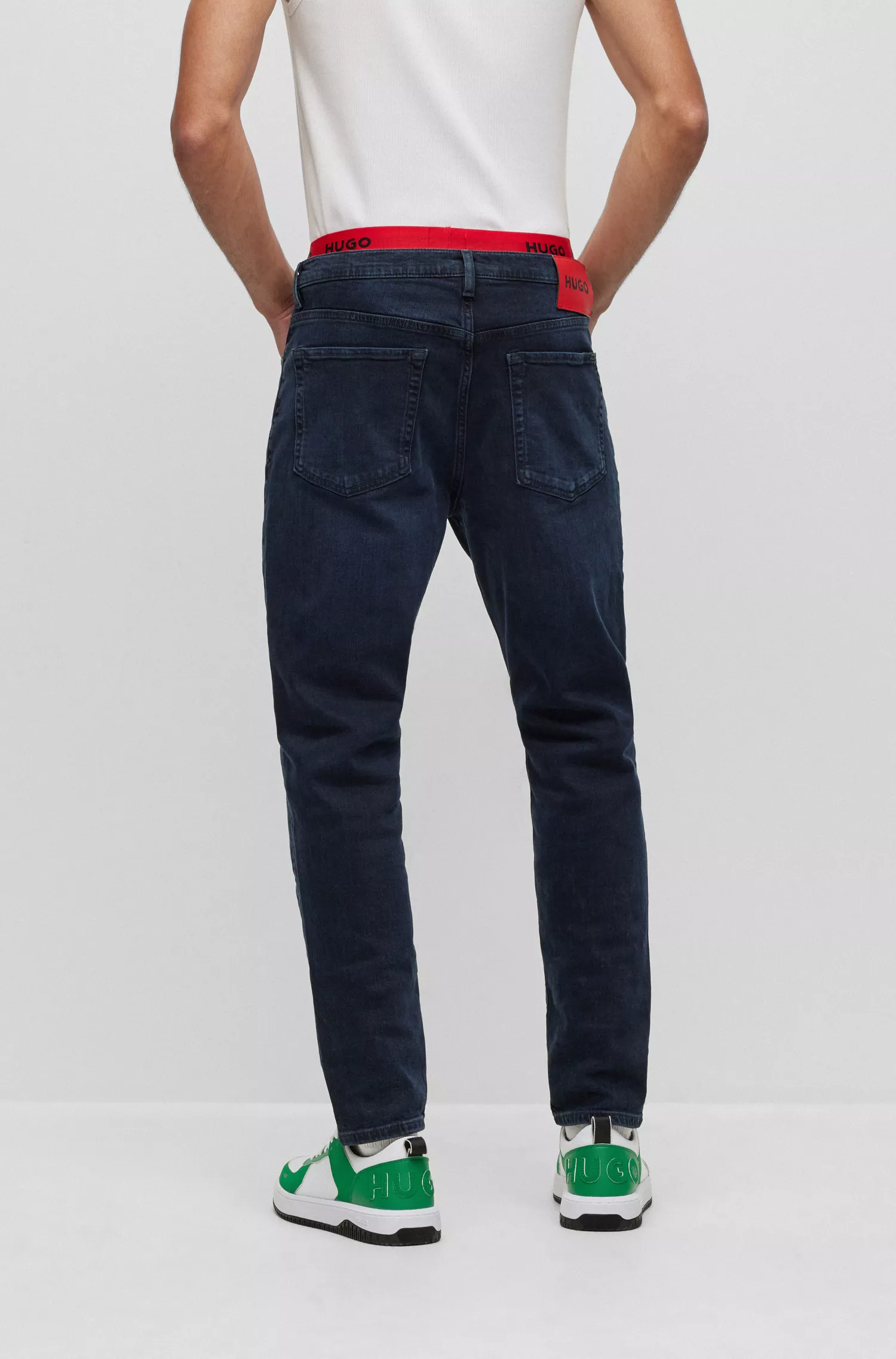 Calça jeans HUGO vermelha, corte afunilado, em denim azul-escuro.