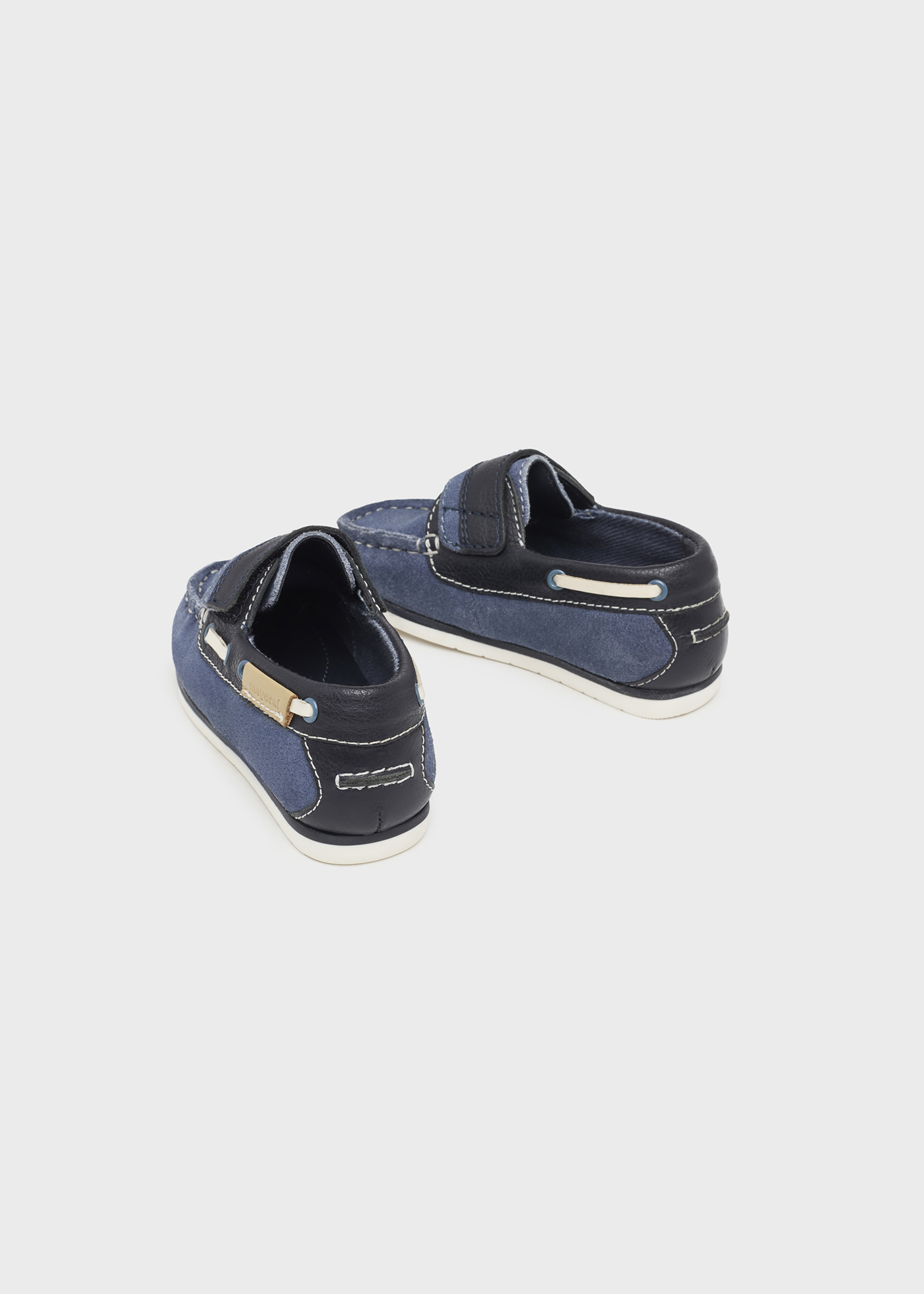 Sapato náutico infantil de couro com cordão decorativo.