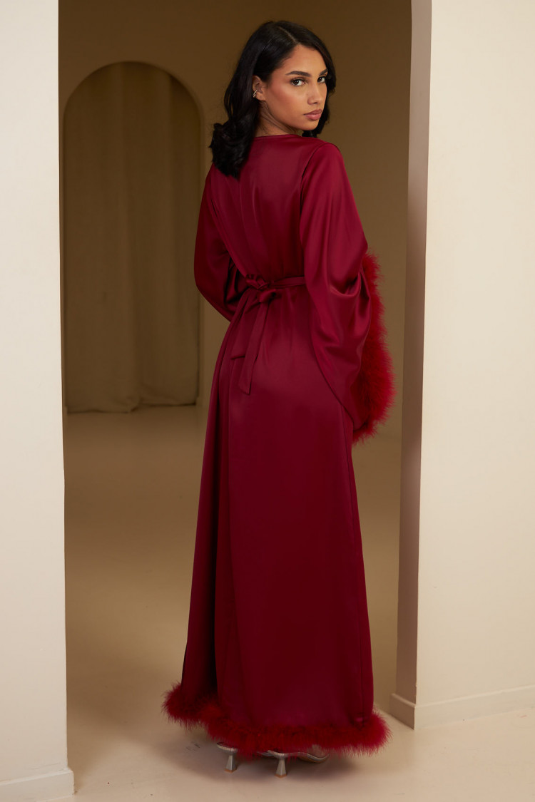 Robe longue rouge satinée et ceinturée à plumes