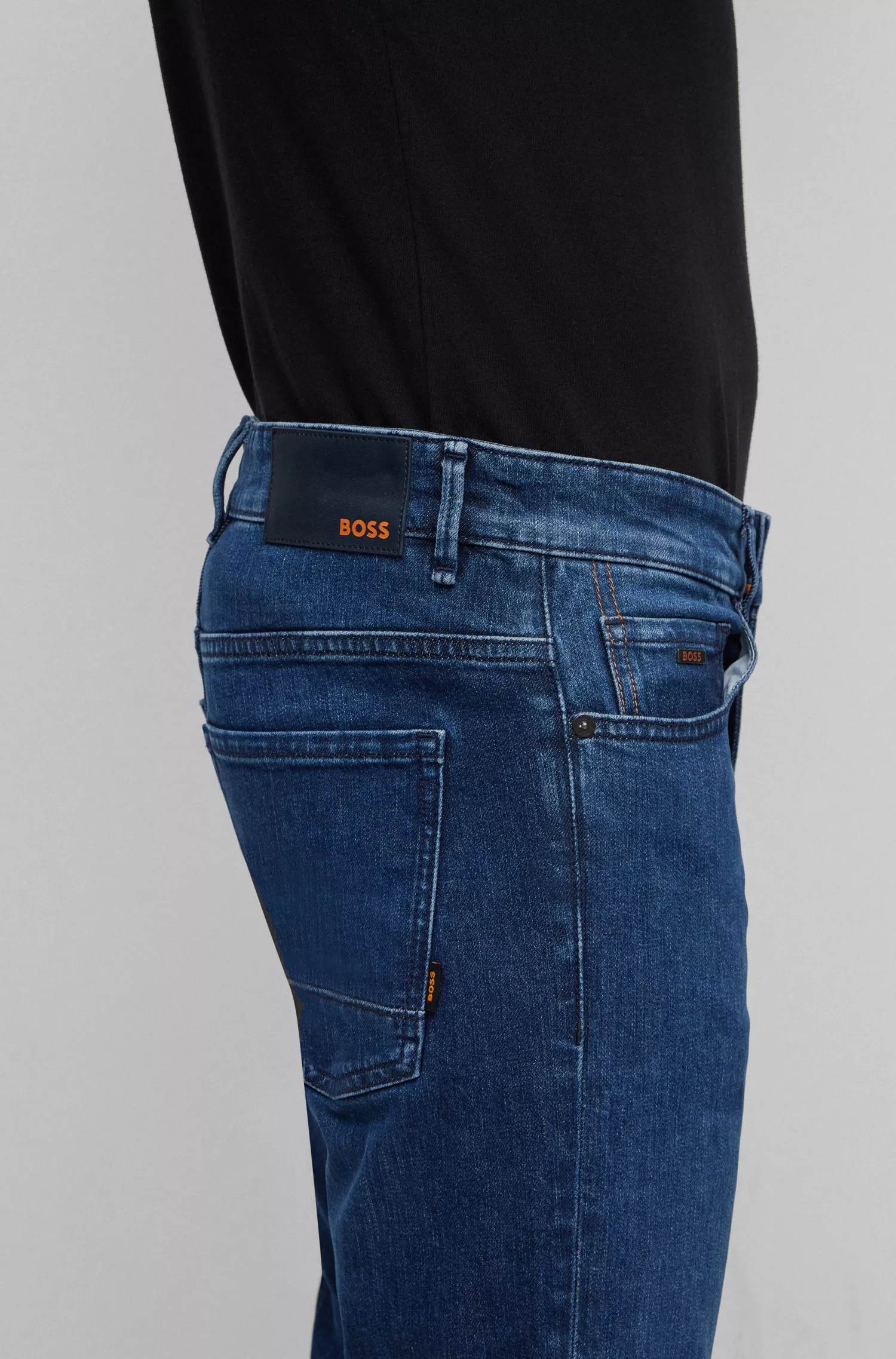 Calça jeans BOSS laranja, corte slim, em denim azul com elasticidade confortável.