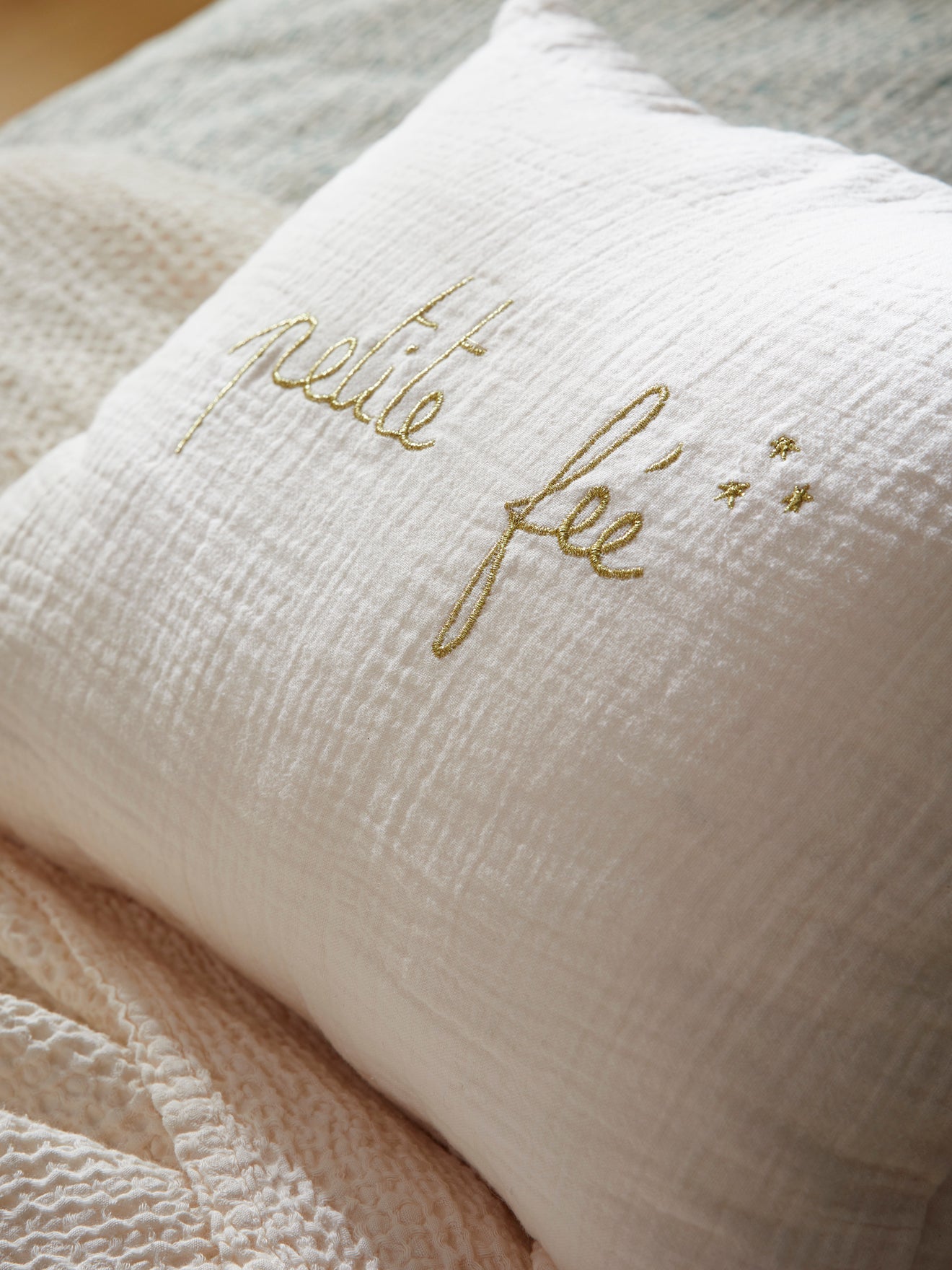 Coussin en gaze de coton à broderie dorée