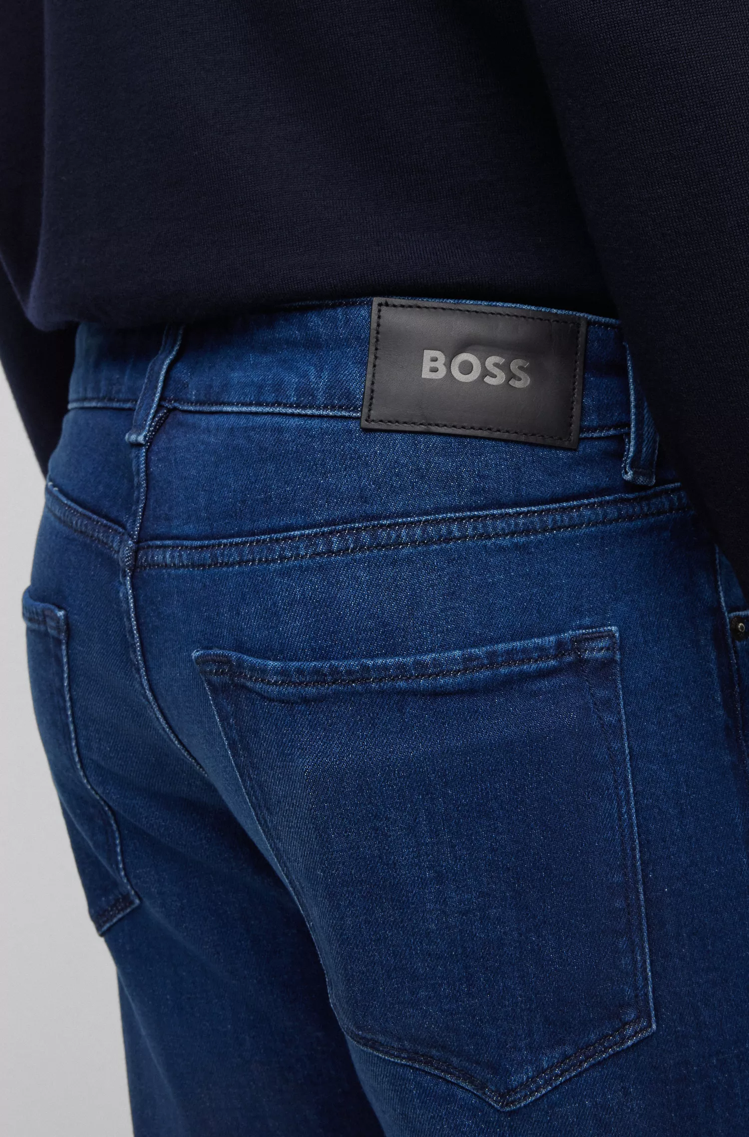 Calça jeans BOSS preta, corte regular, em denim azul-escuro com elasticidade confortável.