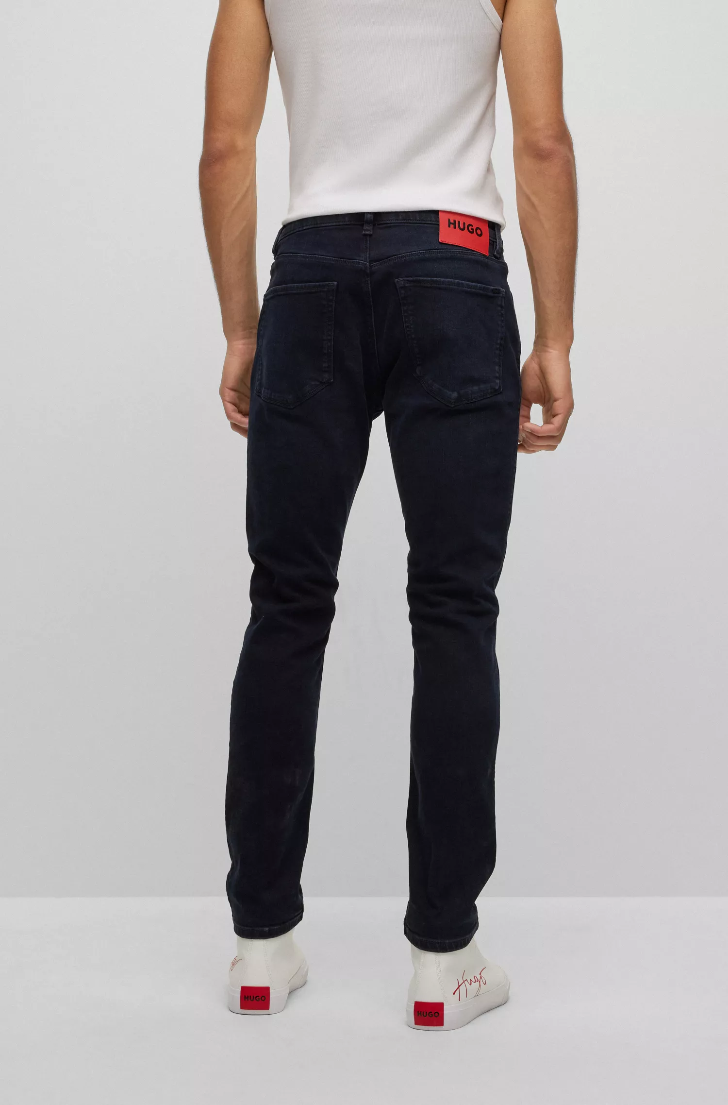 Calça jeans HUGO vermelha, extra slim fit, em denim stretch azul-preto.