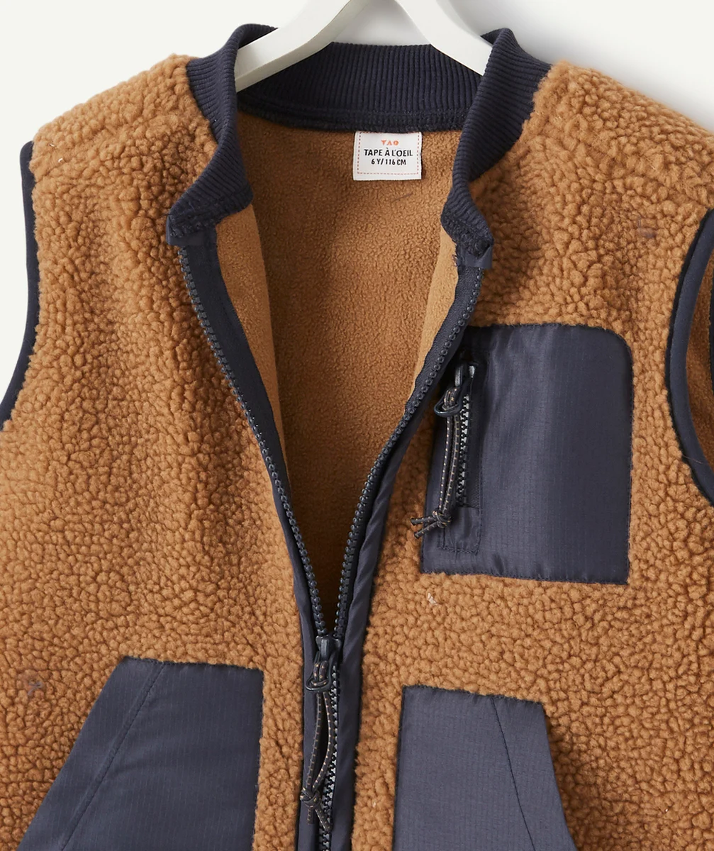 LA VESTE SANS MANCHES MARRON EN BOUCLETTES AVEC POCHES