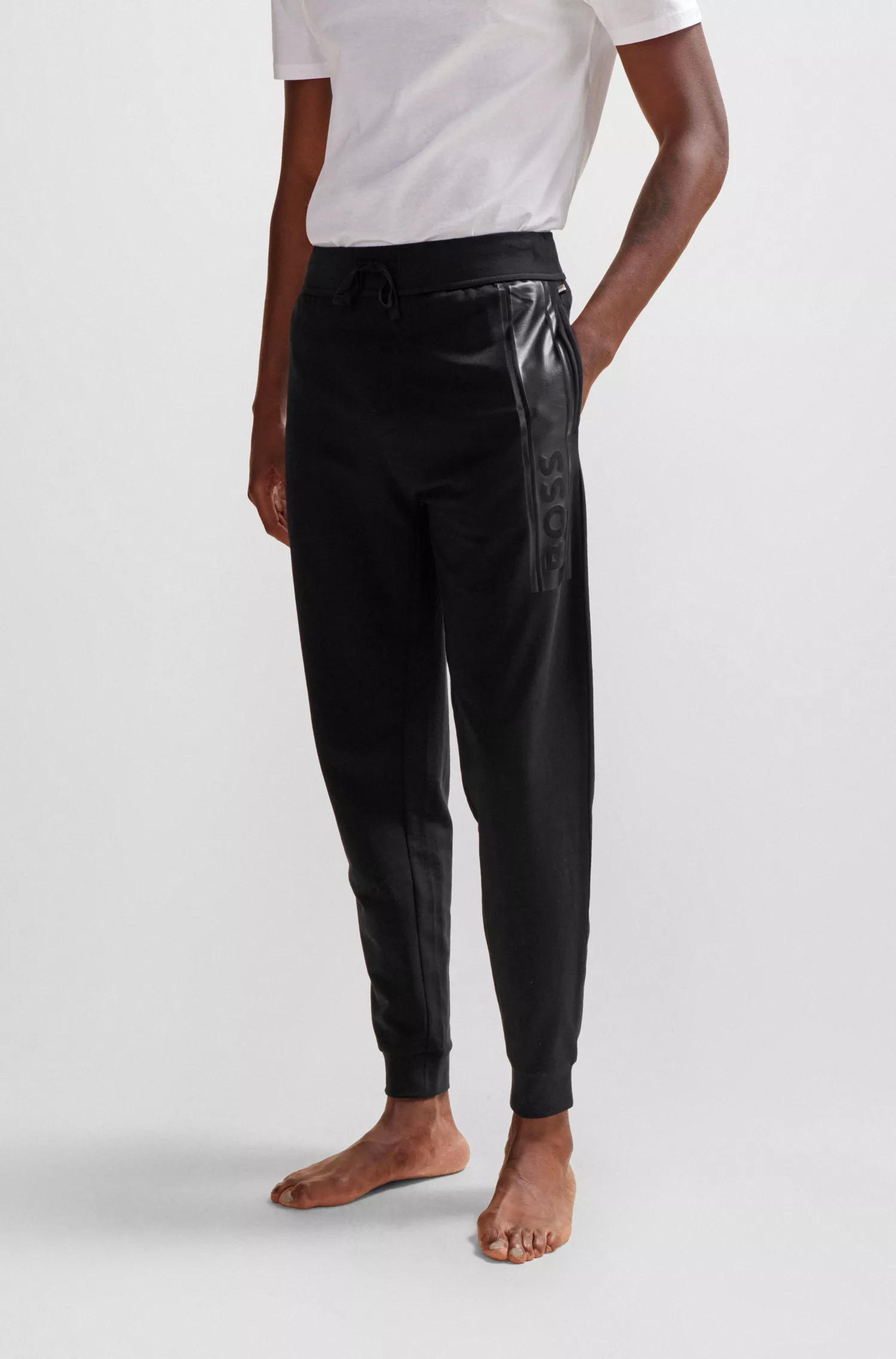 Calça de fato de treino BOSS preta com punhos, em tecido felpudo francês e estampa com o logótipo.