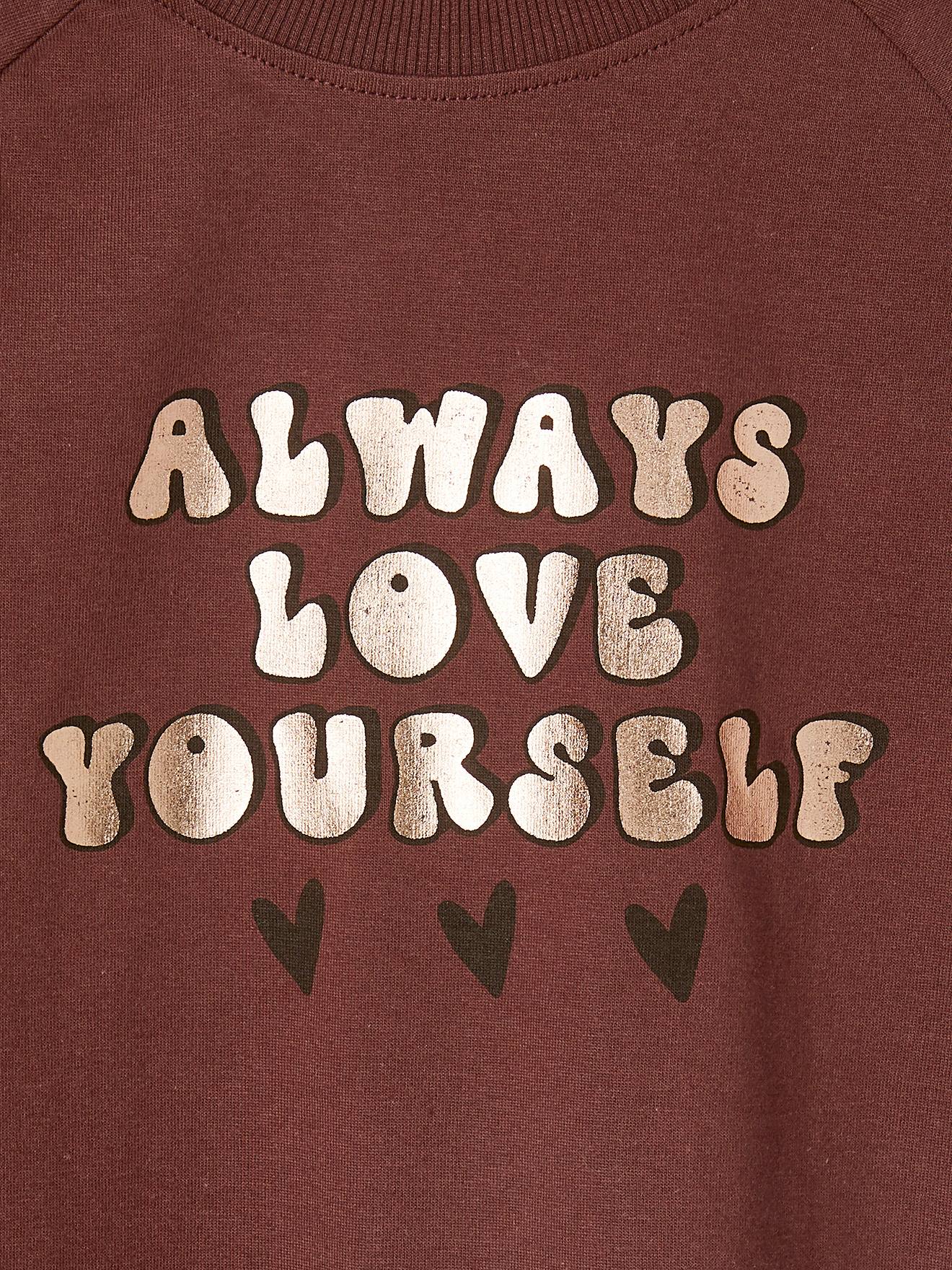 Camiseta evasê com mensagem vibrante e efeito metálico para meninas com maquiagem rosa.