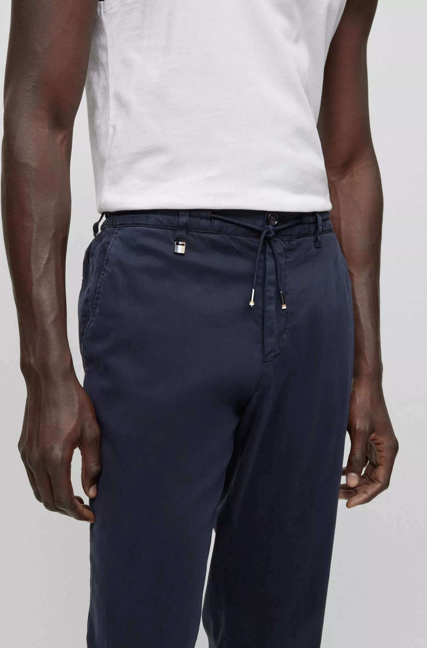 Calça BOSS preta, corte slim, com cintura ajustável por cordão, em tecido elástico.