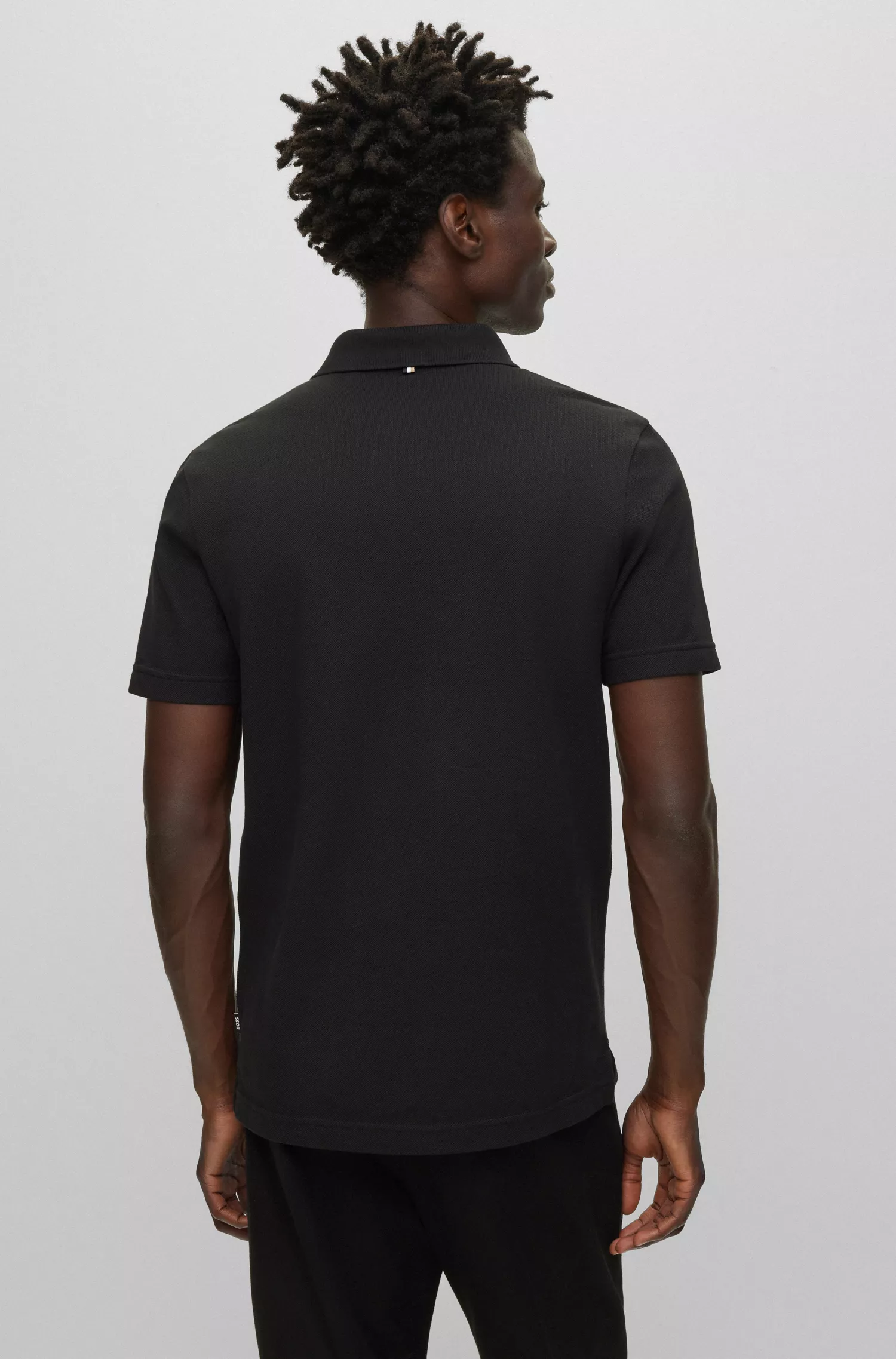 Camisa polo BOSS preta em algodão mercerizado com listra e logotipos característicos.