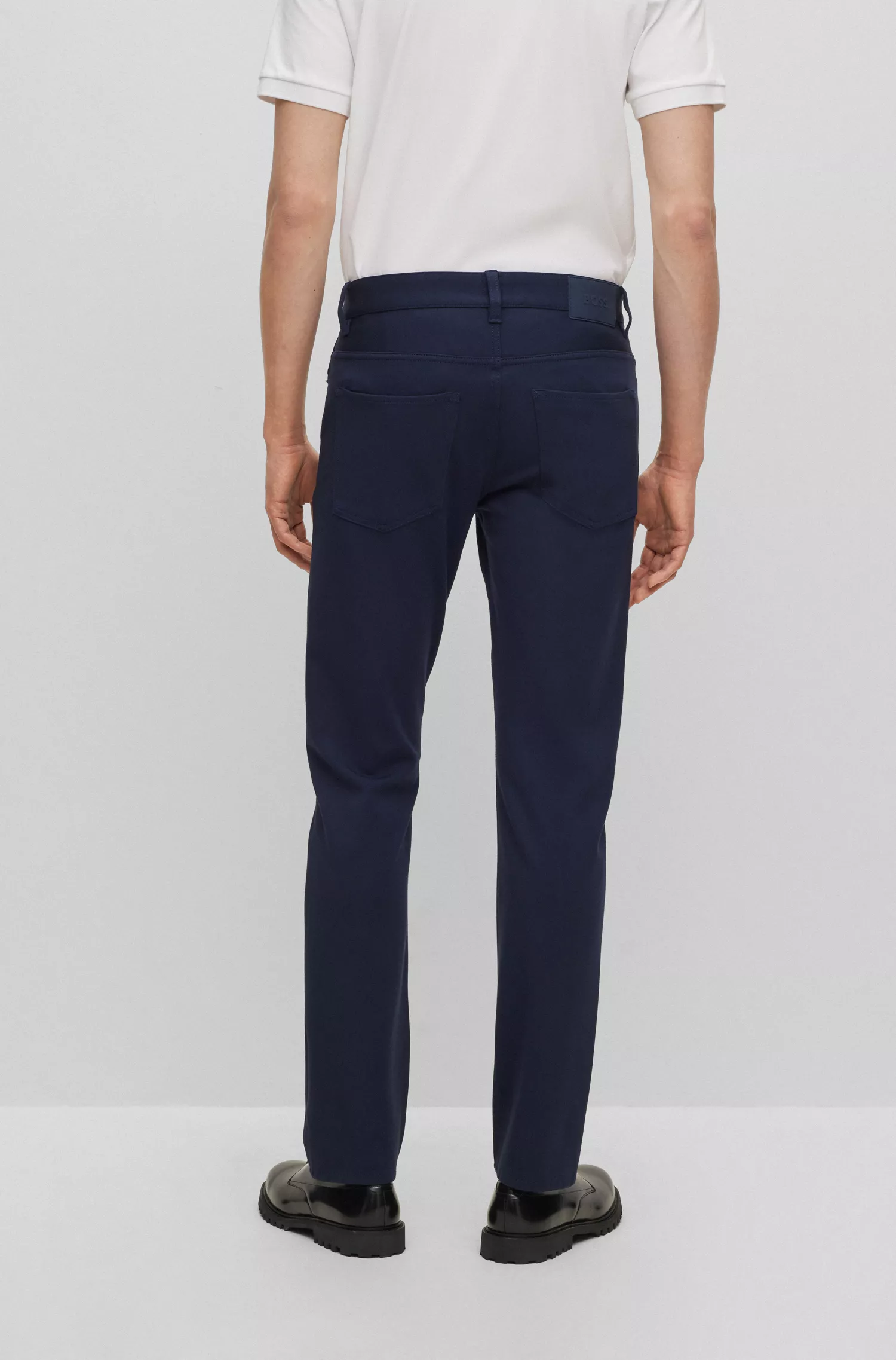 Calça jeans BOSS preta, corte slim, em malha elástica antirrugas.