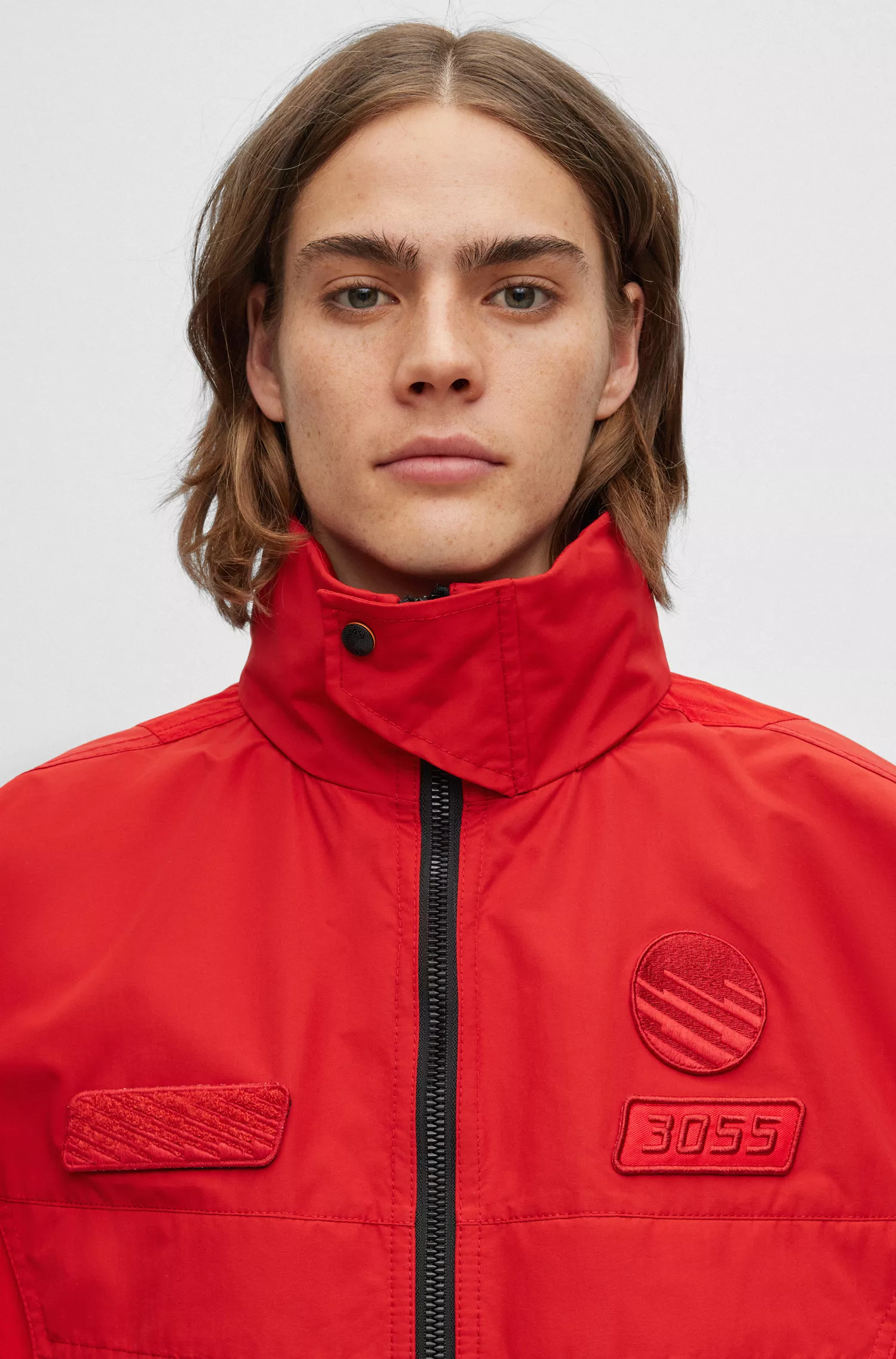 Jaqueta BOSS laranja, modelagem oversized com zíper e detalhes inspirados em corridas.