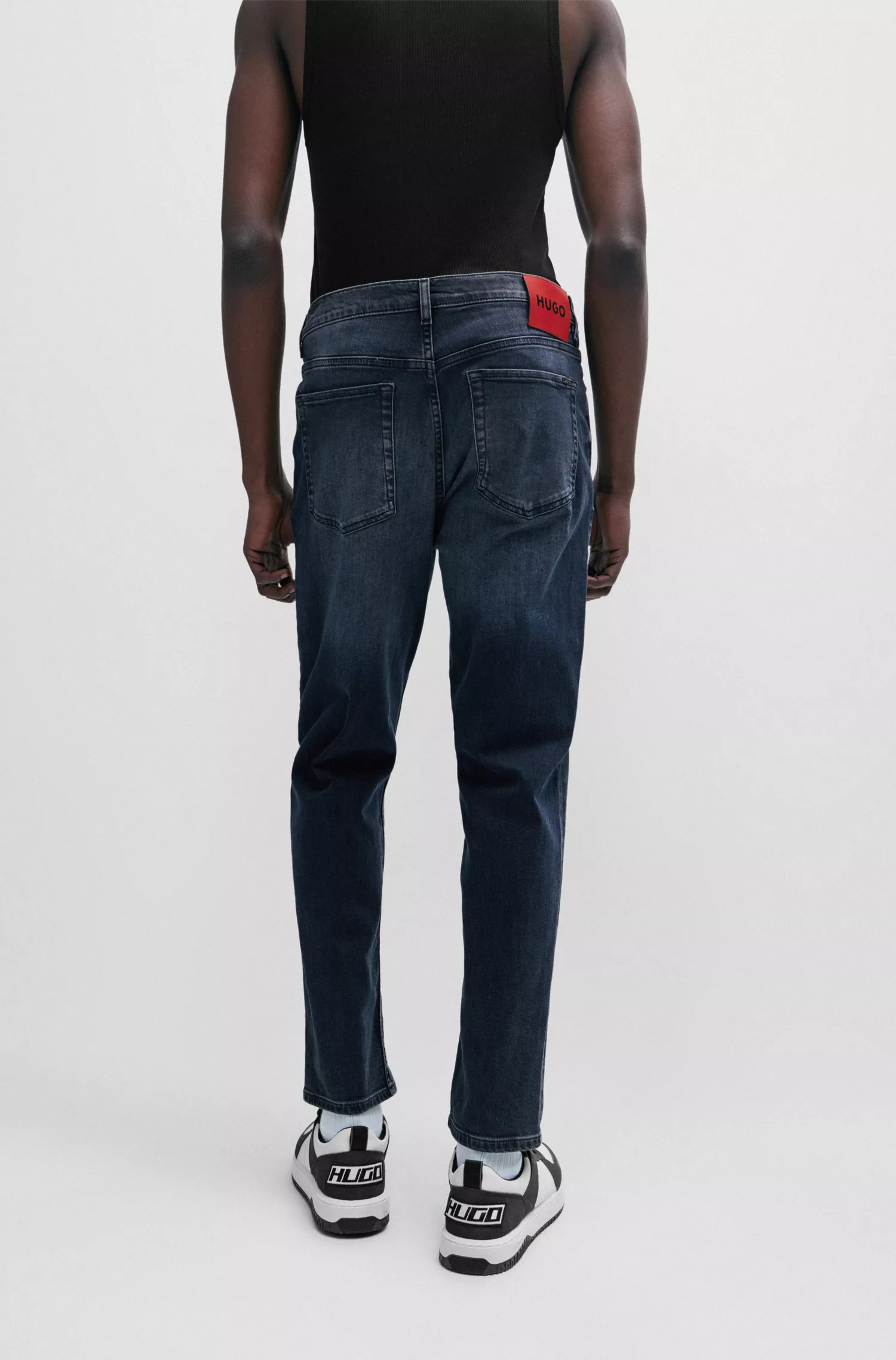 Calça jeans HUGO vermelha, corte afunilado, em denim elástico azul.