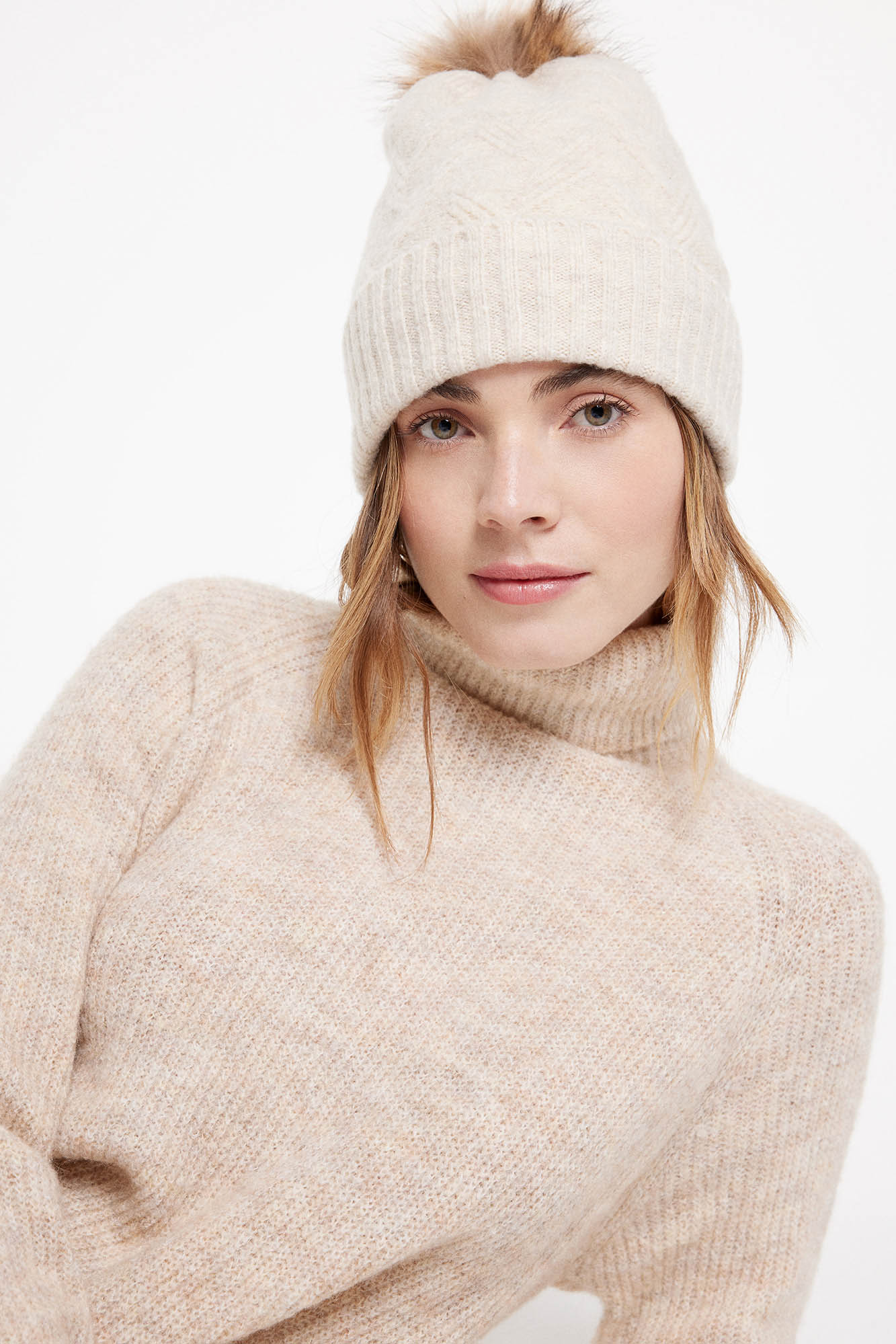 Gorro de tricô com detalhes estampados. Aba enrolada e textura macia. Contém um pompom.