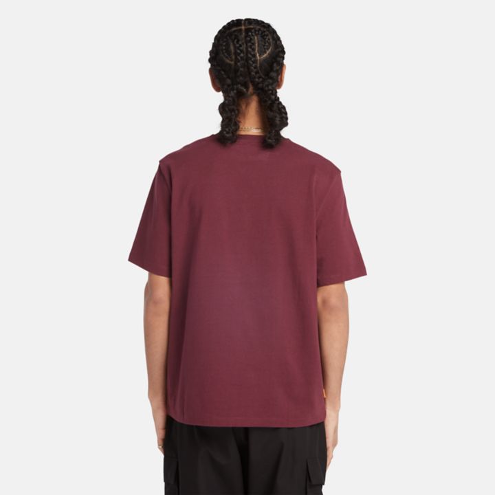 Camiseta unissex de tecido pesado com emblema na cor bordô.