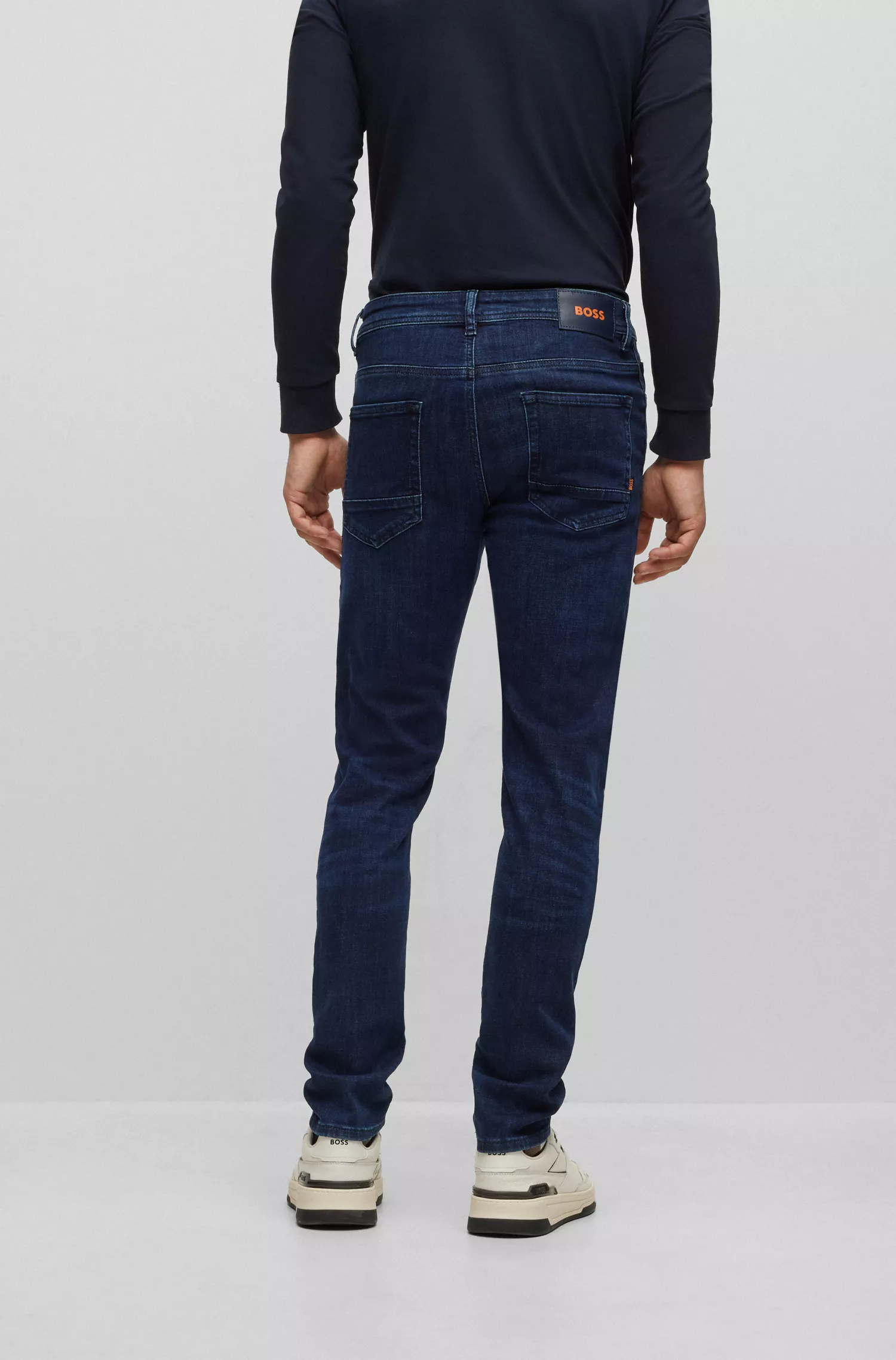 Calça jeans BOSS laranja, corte afunilado, em denim superelástico azul-escuro.