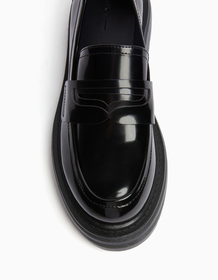 Mocassins com tira de metal e solado tratorado.