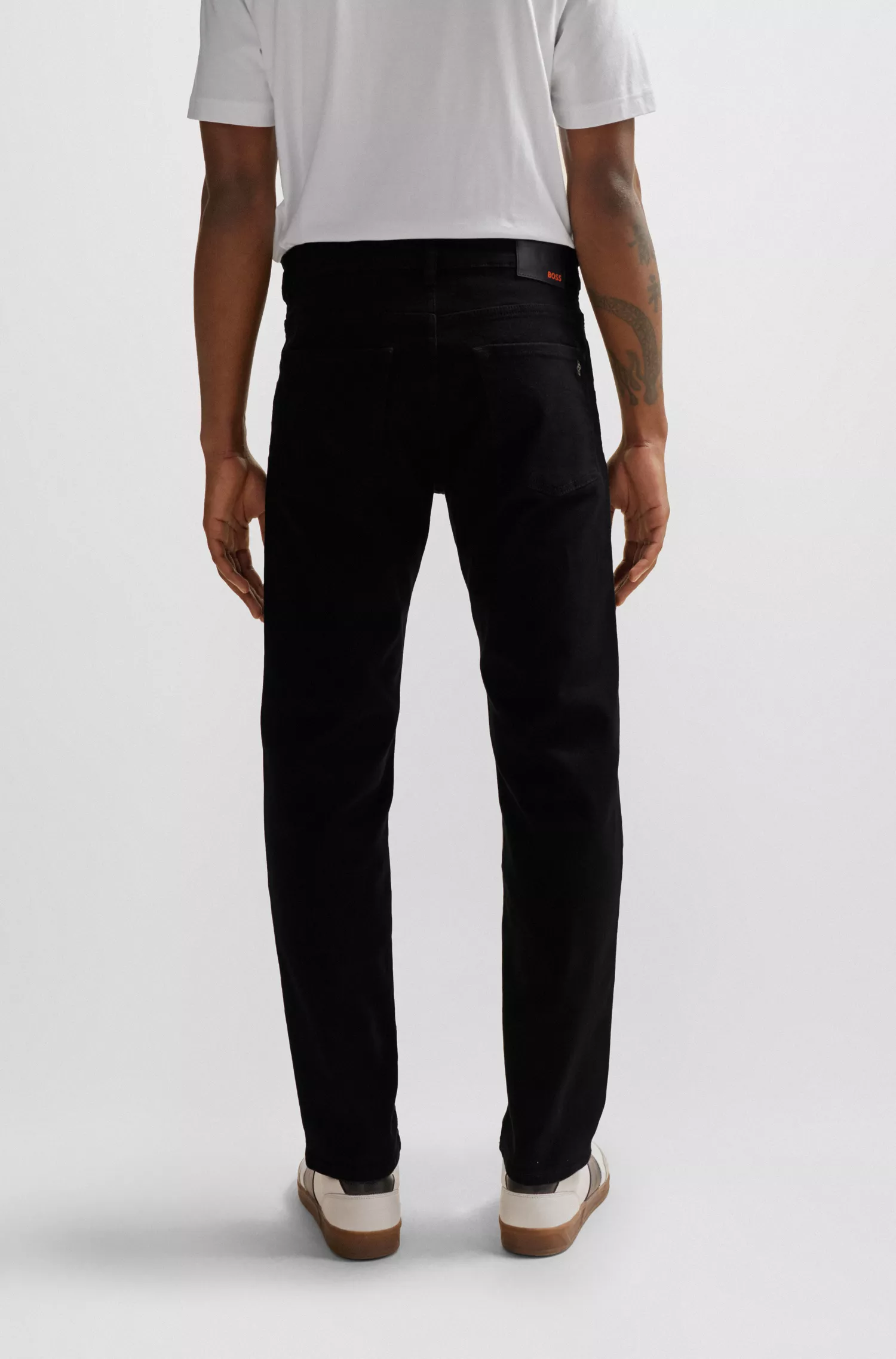 Calça jeans BOSS laranja, corte regular, em denim confortável com elasticidade que mantém a cor preta.