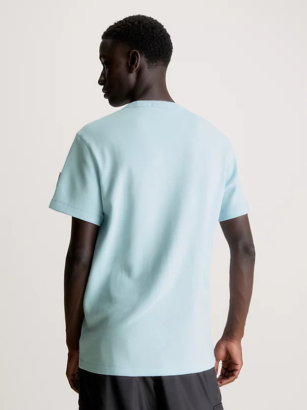 Camiseta de algodão com textura alveolar e modelagem slim, com brasão.