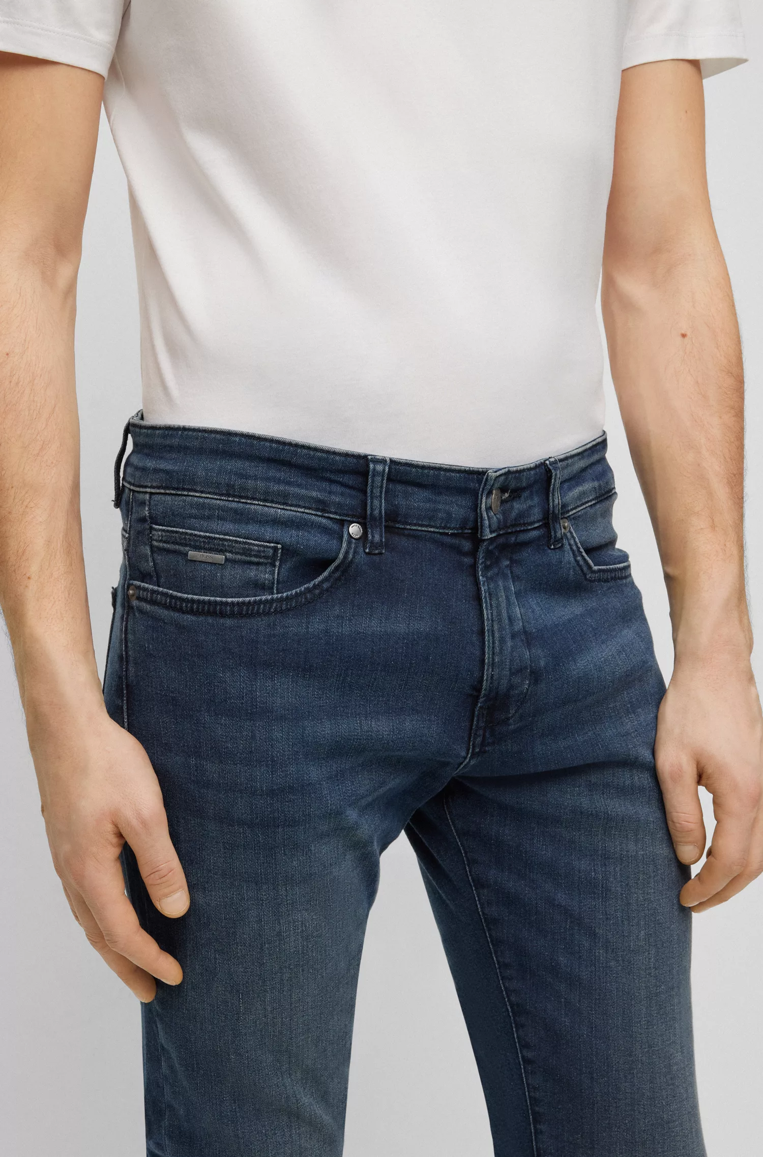 Calça jeans BOSS preta, corte slim, em denim super elástico tingido de azul.