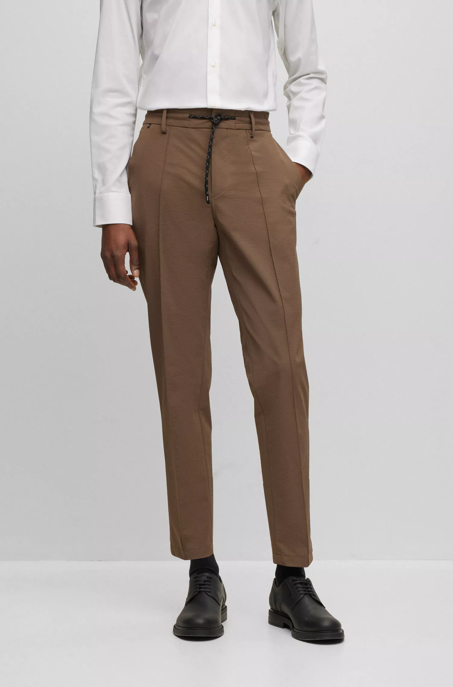 Calças BOSS pretas de corte slim em tecido elástico de alta performance com propriedades repelentes à água.