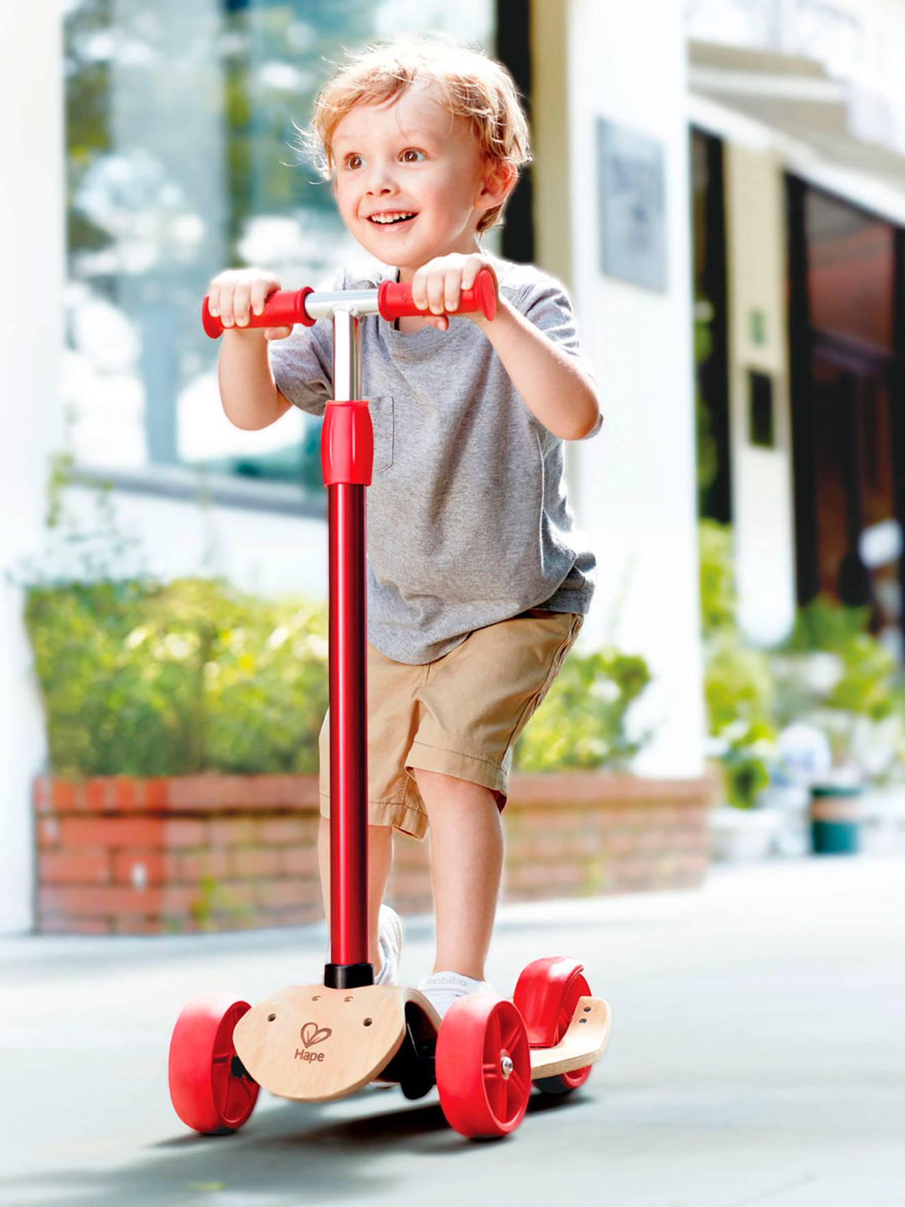 Patinete HAPE, vermelho claro, liso com detalhes.