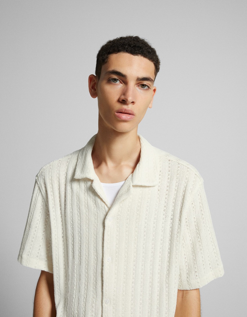 Camisa de malha jacquard aberta com mangas curtas.