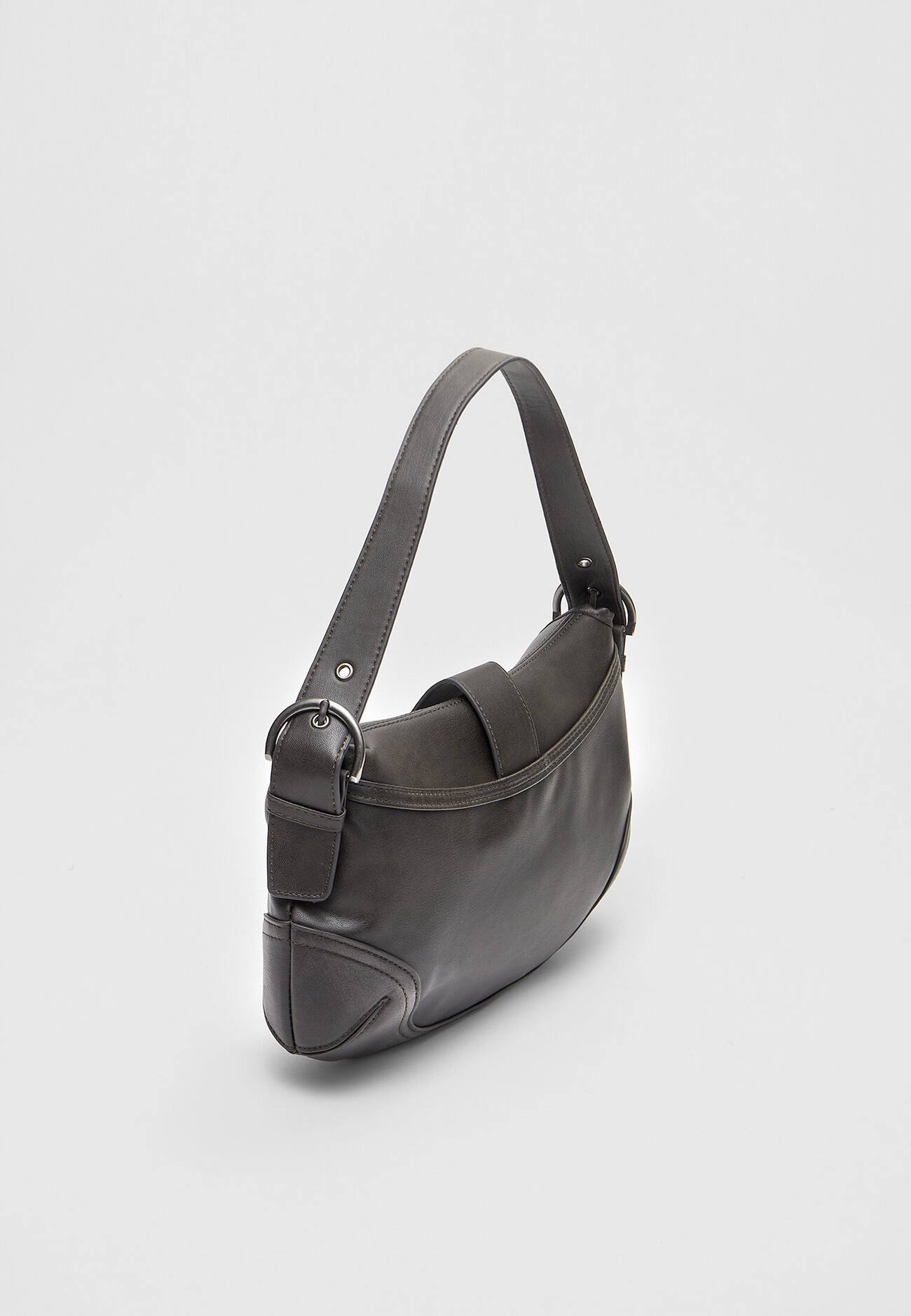 Bolsa de ombro com acabamento desgastado e fivela.