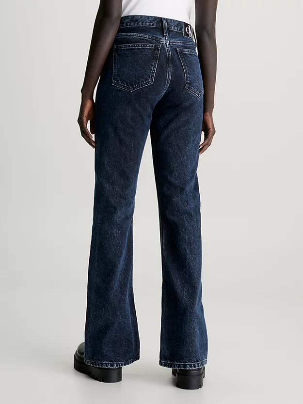 Calça jeans boca de sino com fenda na barra.