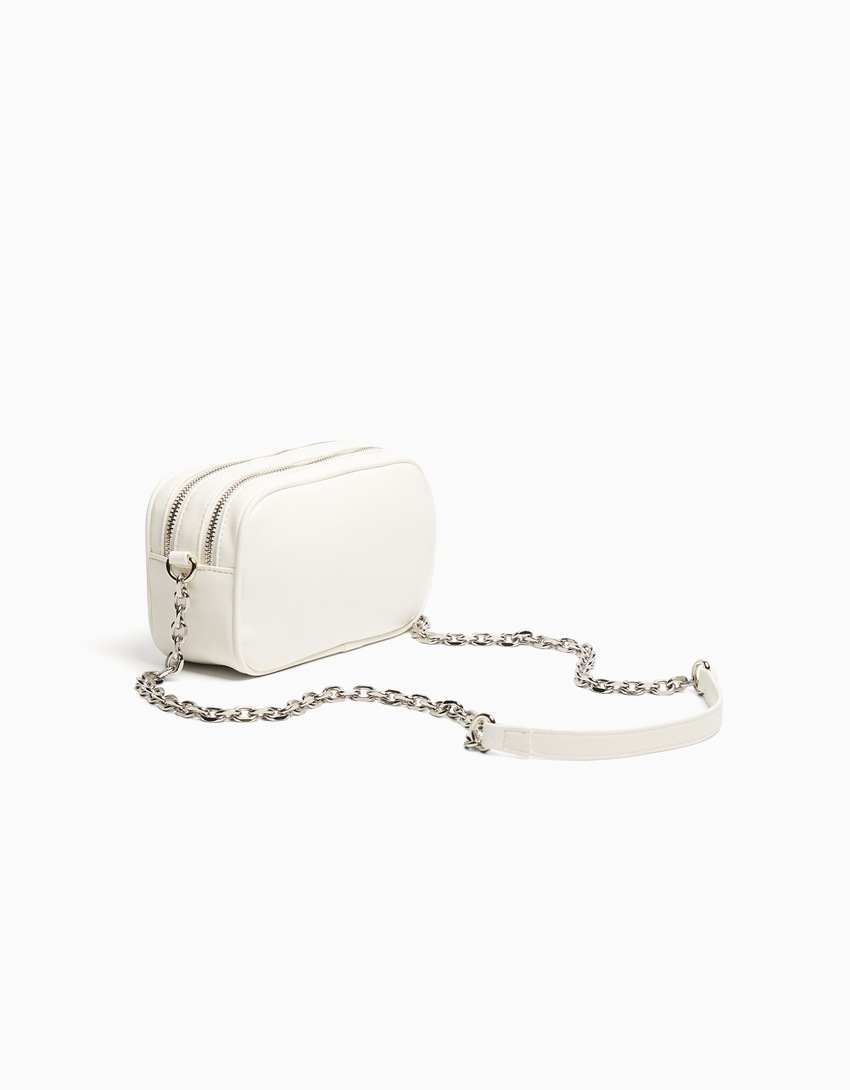 Bolsa transversal com fecho duplo de zíper e corrente.