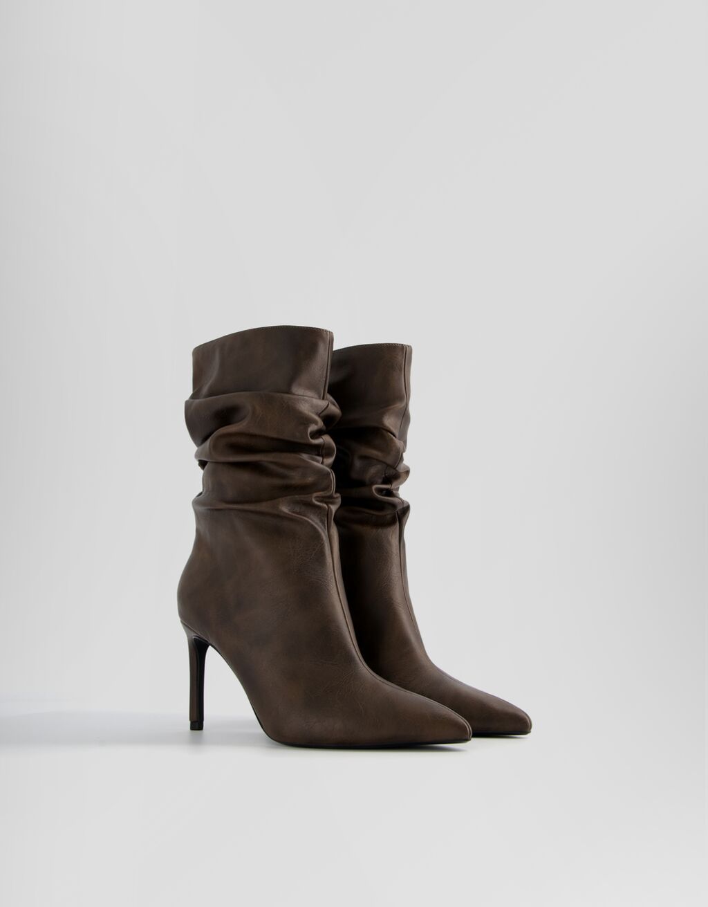 Botas de cano curto com salto agulha e modelagem folgada
