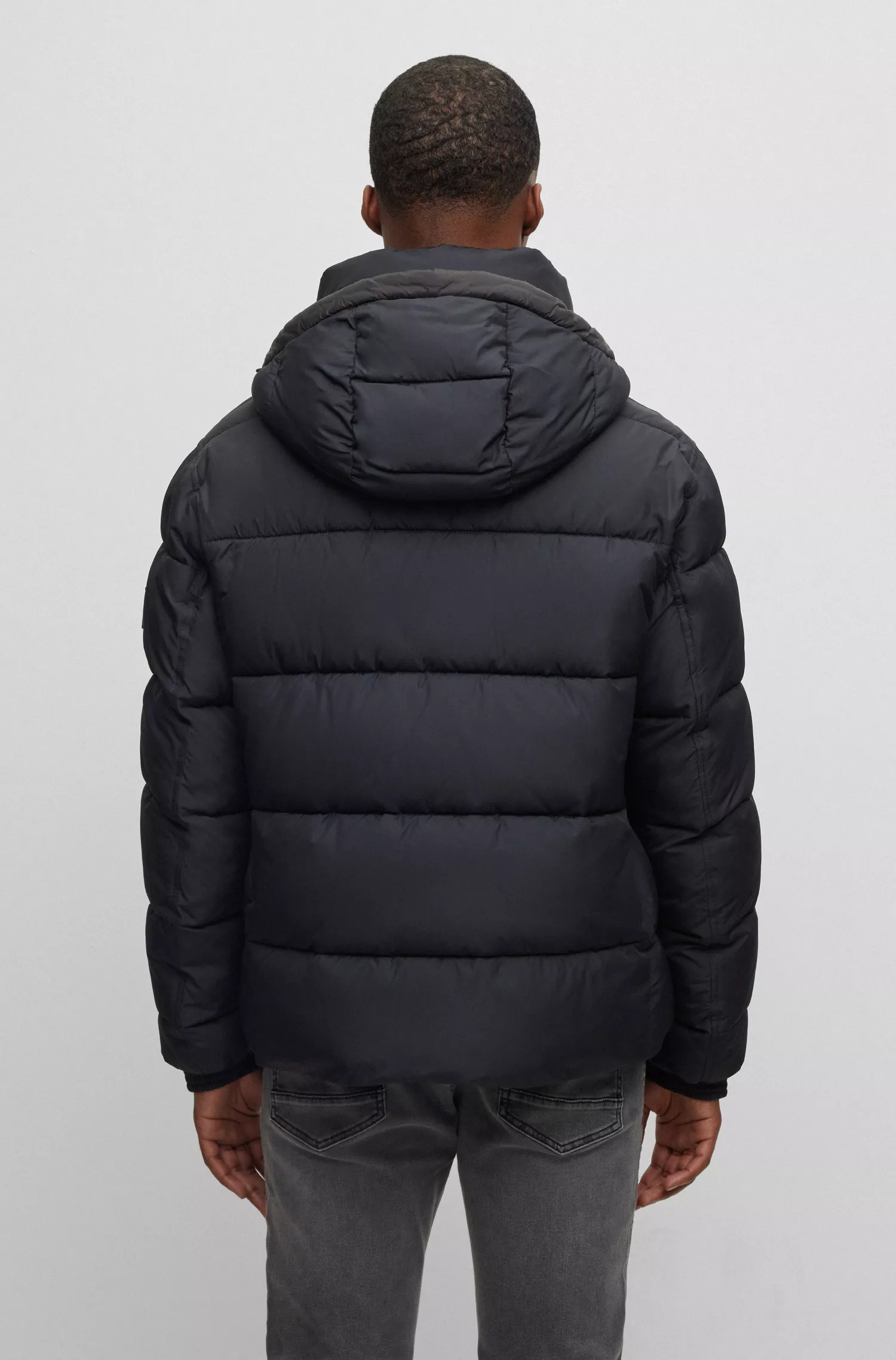 Jaqueta puffer com capuz BOSS laranja, repelente à água e com emblema da marca.