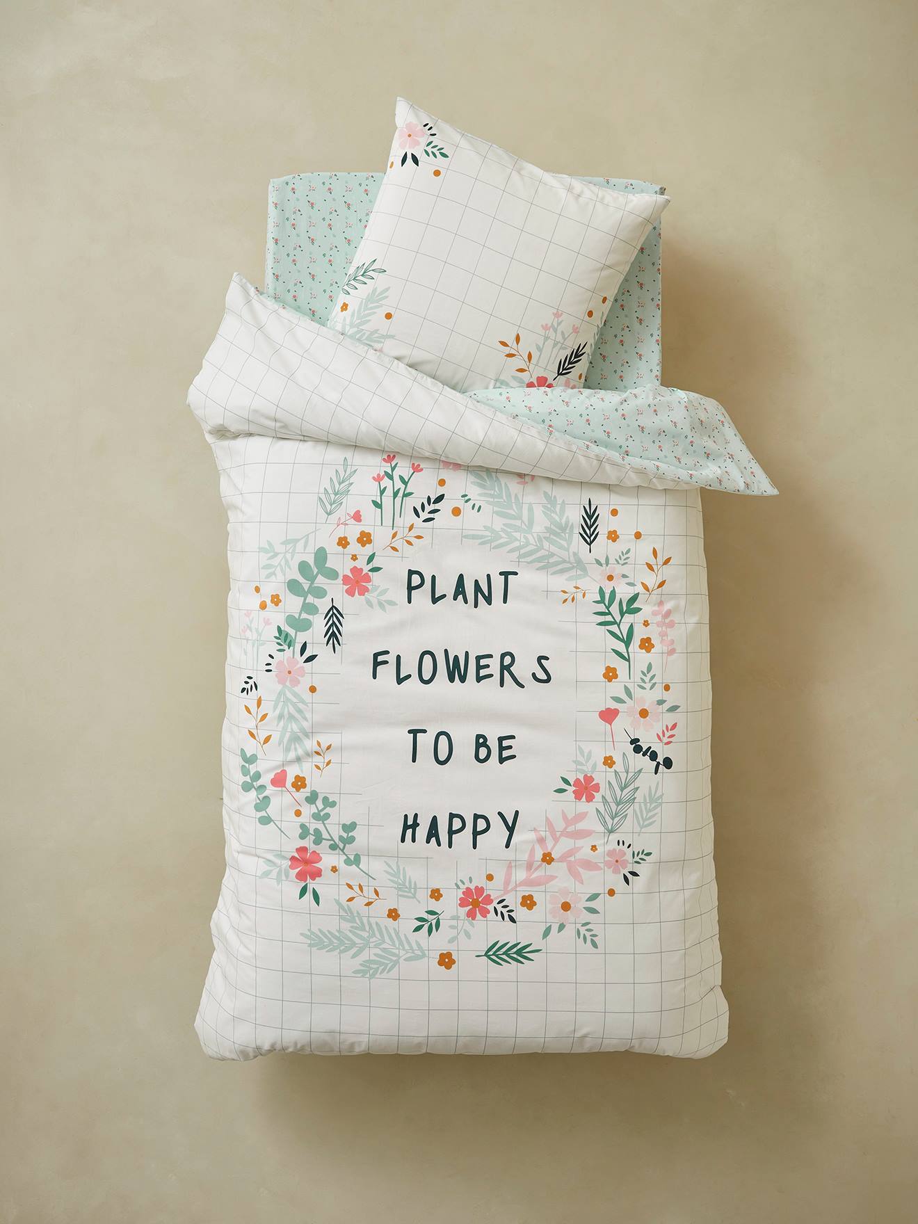 Conjunto de capa de edredom e fronha infantil em algodão orgânico, com estampa floral lisa em branco claro.