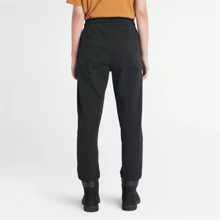 Calça de fato de treino feminina preta com bordado de árvore.