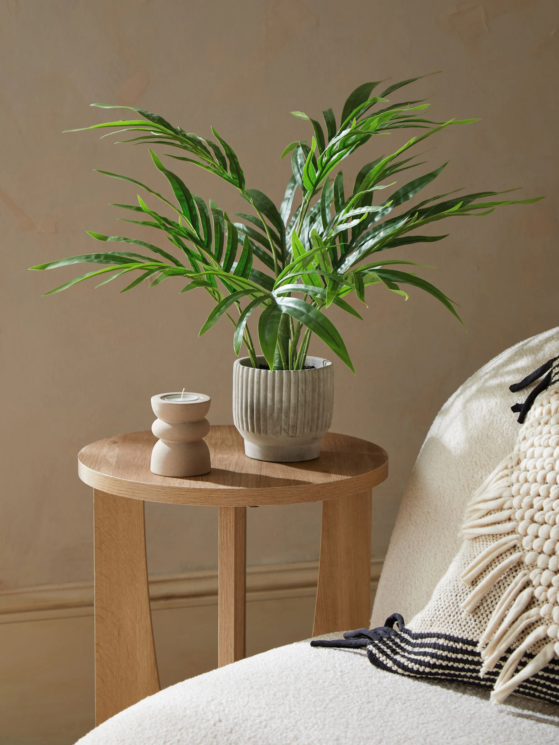 Kleine Kentia-kunstpalmplant in geribbelde betonnen pot