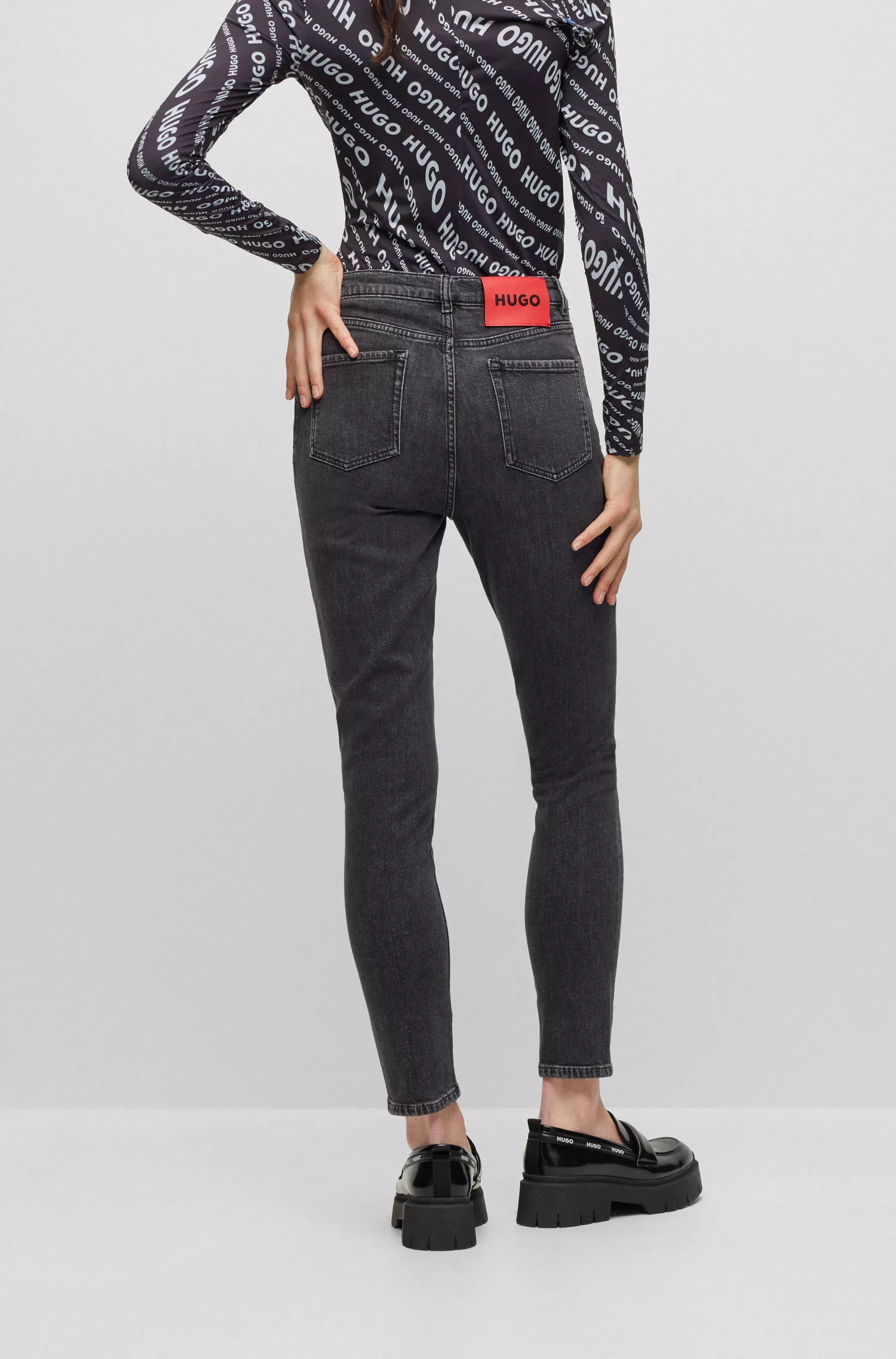 Calça jeans HUGO vermelha, corte slim, em denim stretch preto.