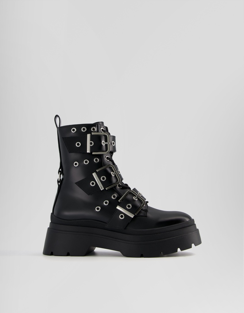Botas de cano curto sem salto, com tiras, ilhós e fivelas.
