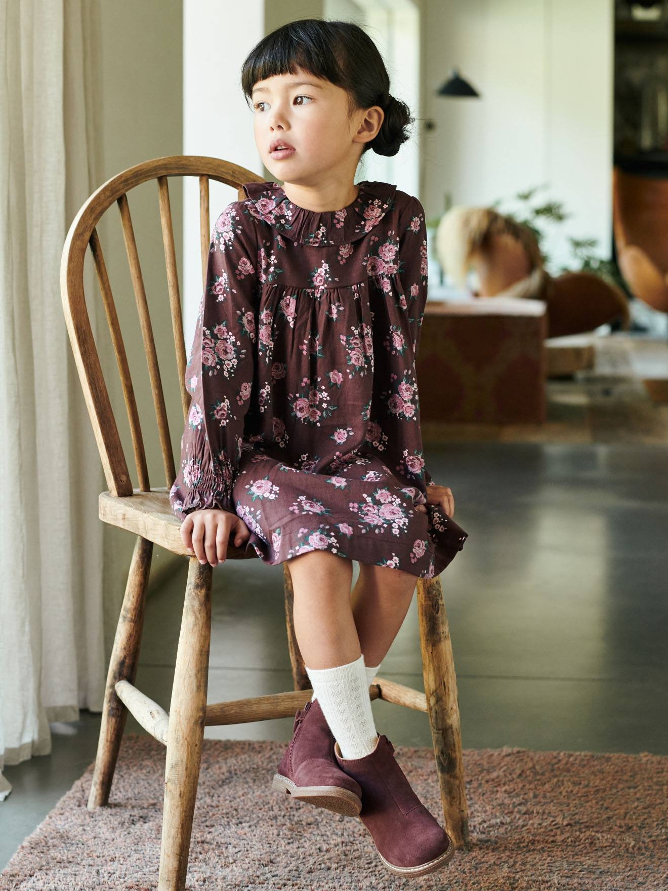 Vestido infantil com estampa floral e babados, na cor marrom escuro.
