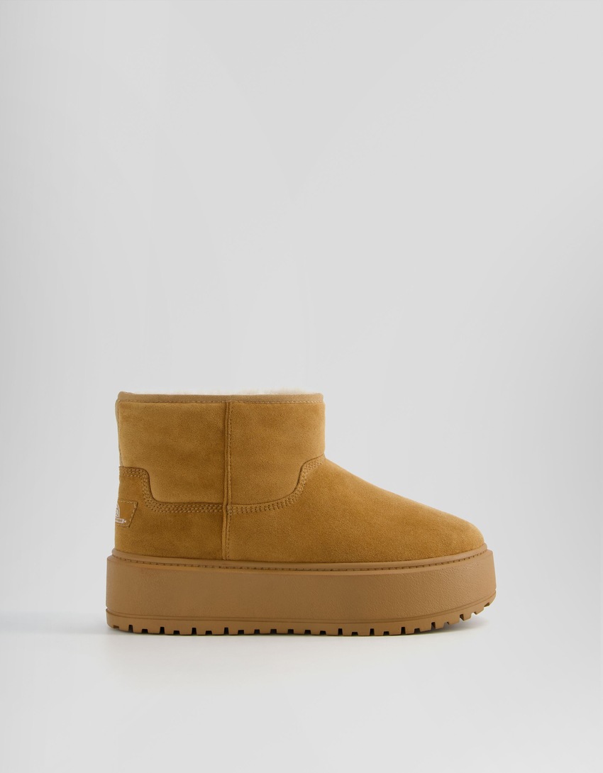 Botas de cano curto com plataforma e forro de pele sintética.