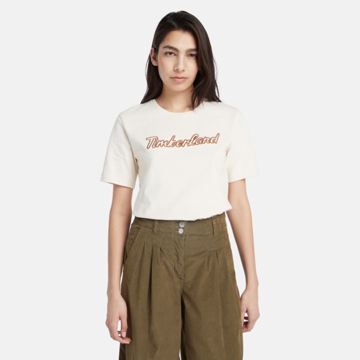 Camiseta feminina bege com logo texturizado.