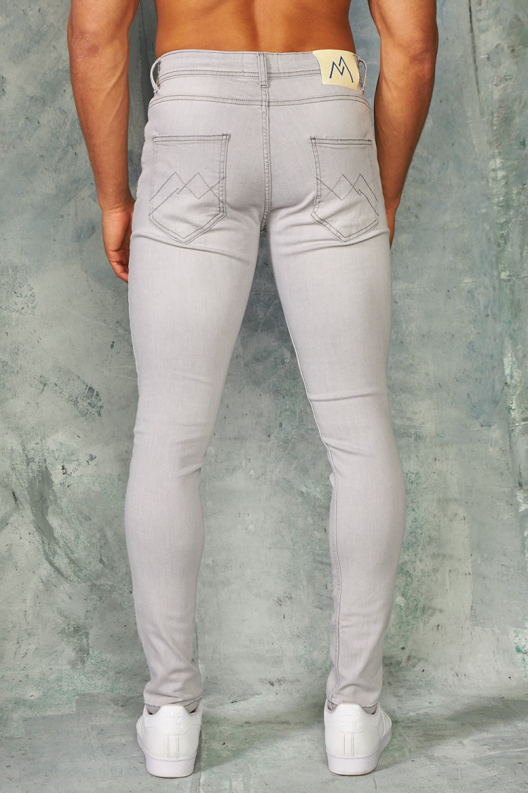 Jeans slim gris déchirures doublées noires