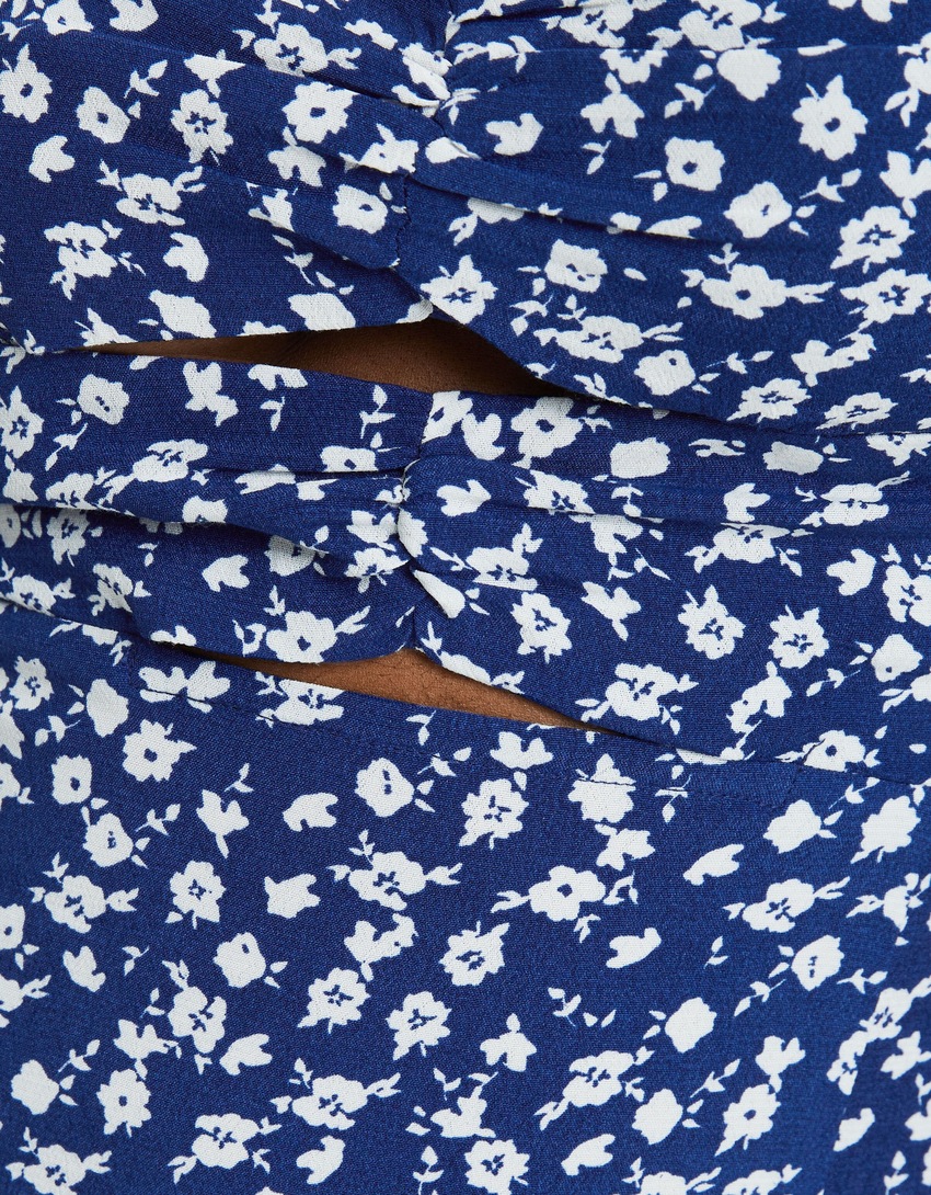 Vestido midi de manga comprida com estampa floral e detalhe vazado.