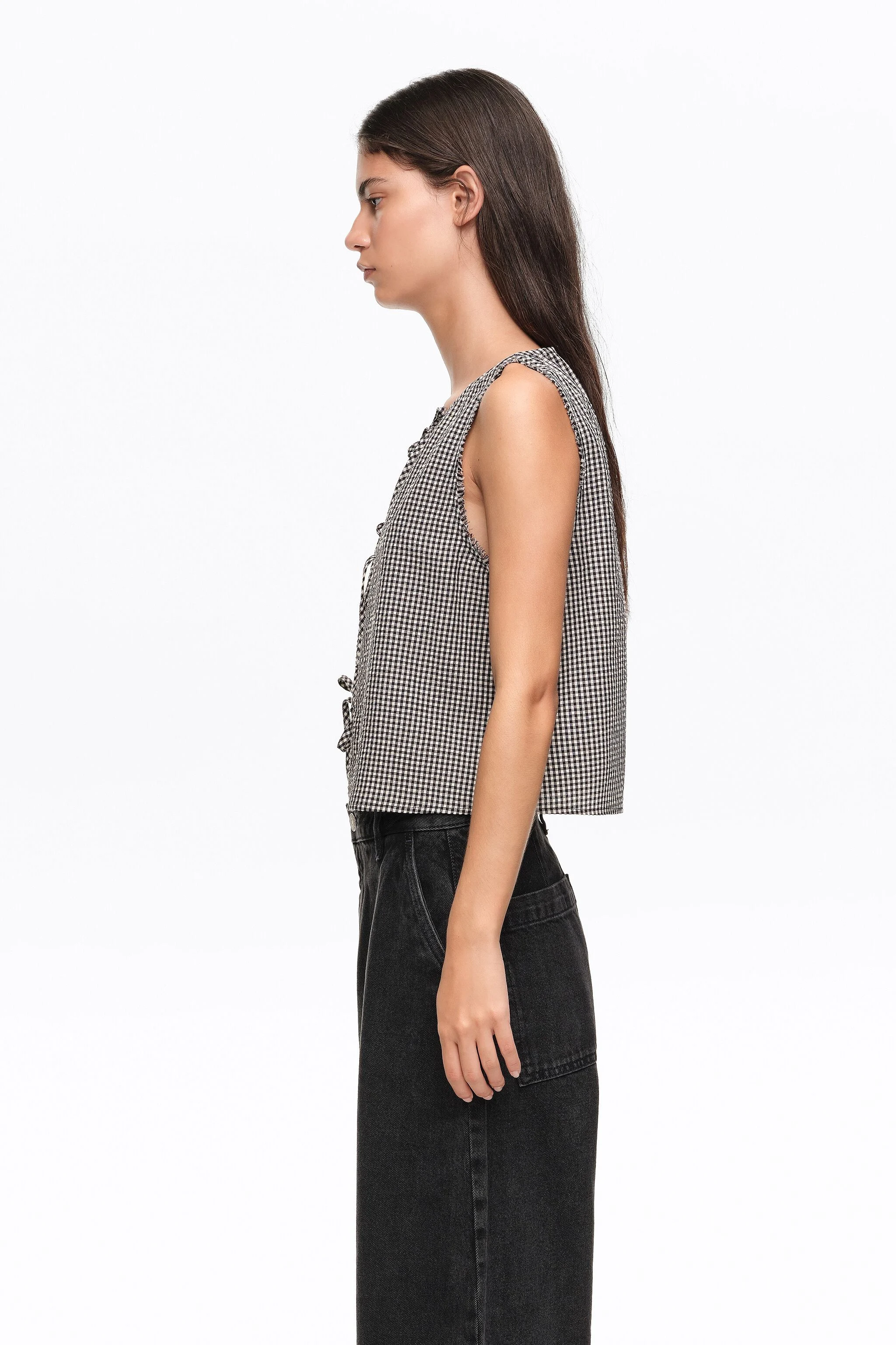 Blusa xadrez preta com laços e detalhes desfiados.