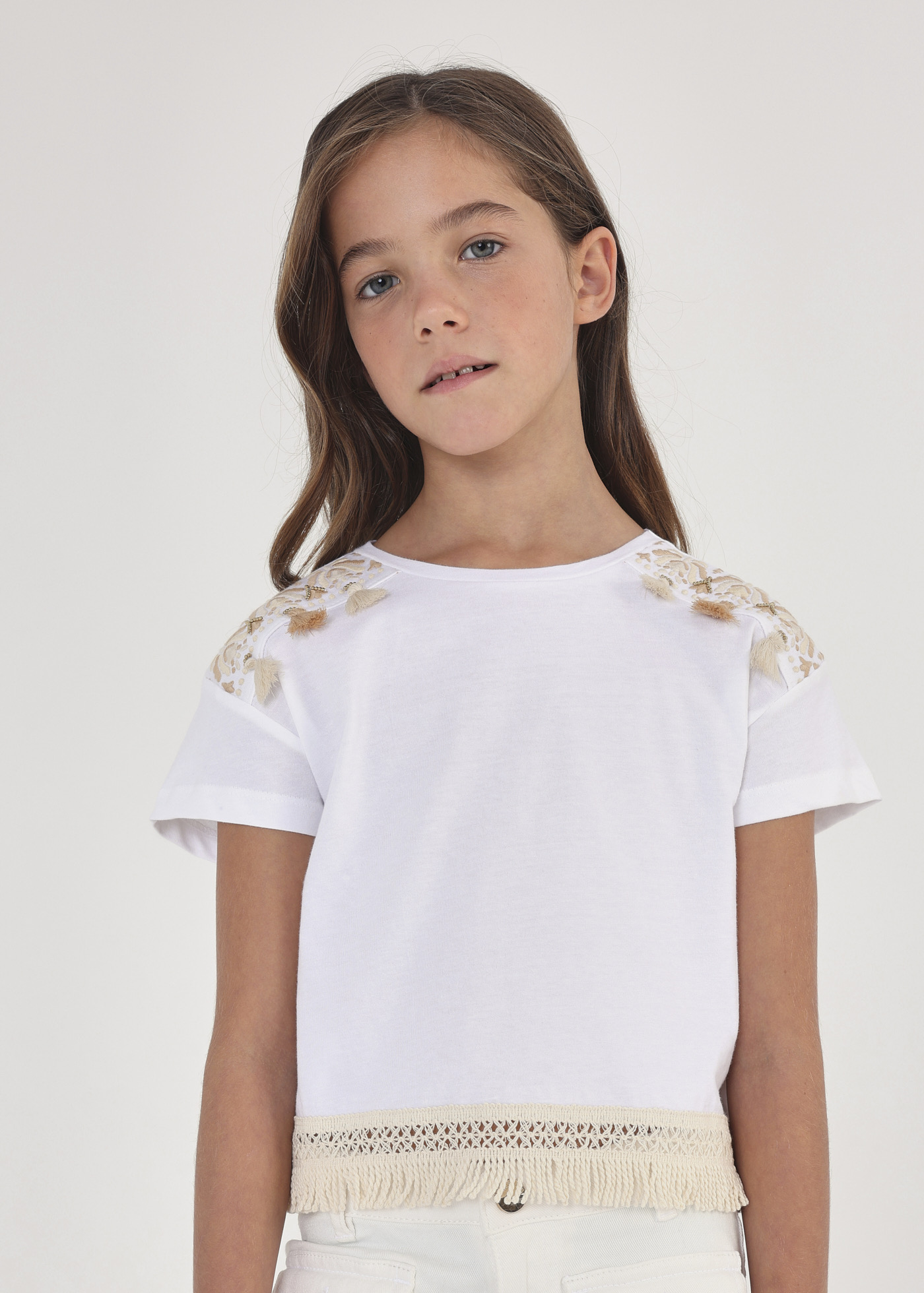 Camiseta infantil de manga curta com franjas, feita de algodão sustentável.