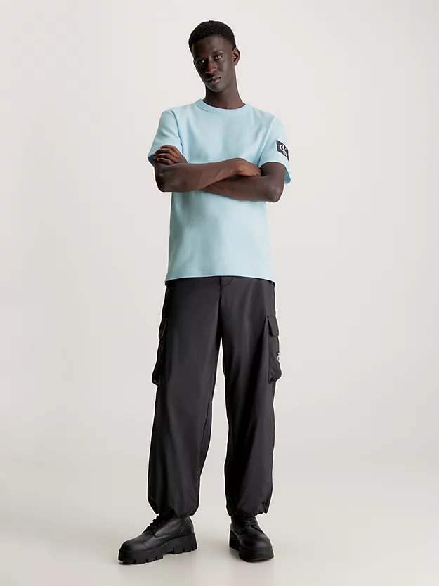 Camiseta de algodão com textura alveolar e modelagem slim, com brasão.