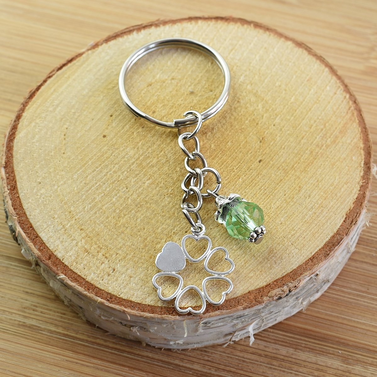 Porte-clés cercle de coeurs argenté et perle à facettes verte