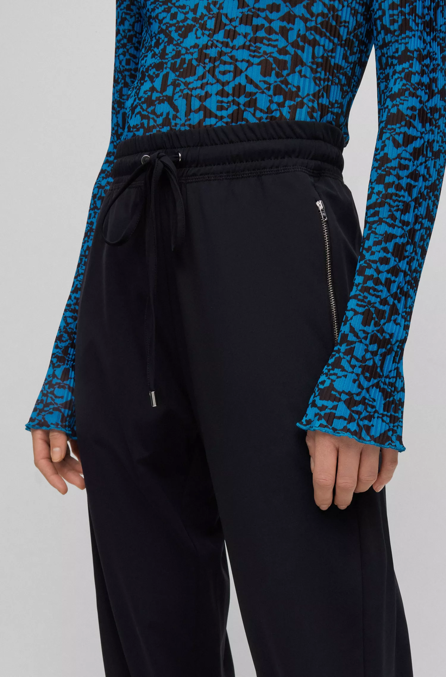 Calça BOSS preta, modelagem relaxada com cordão, em malha elástica de alta performance.