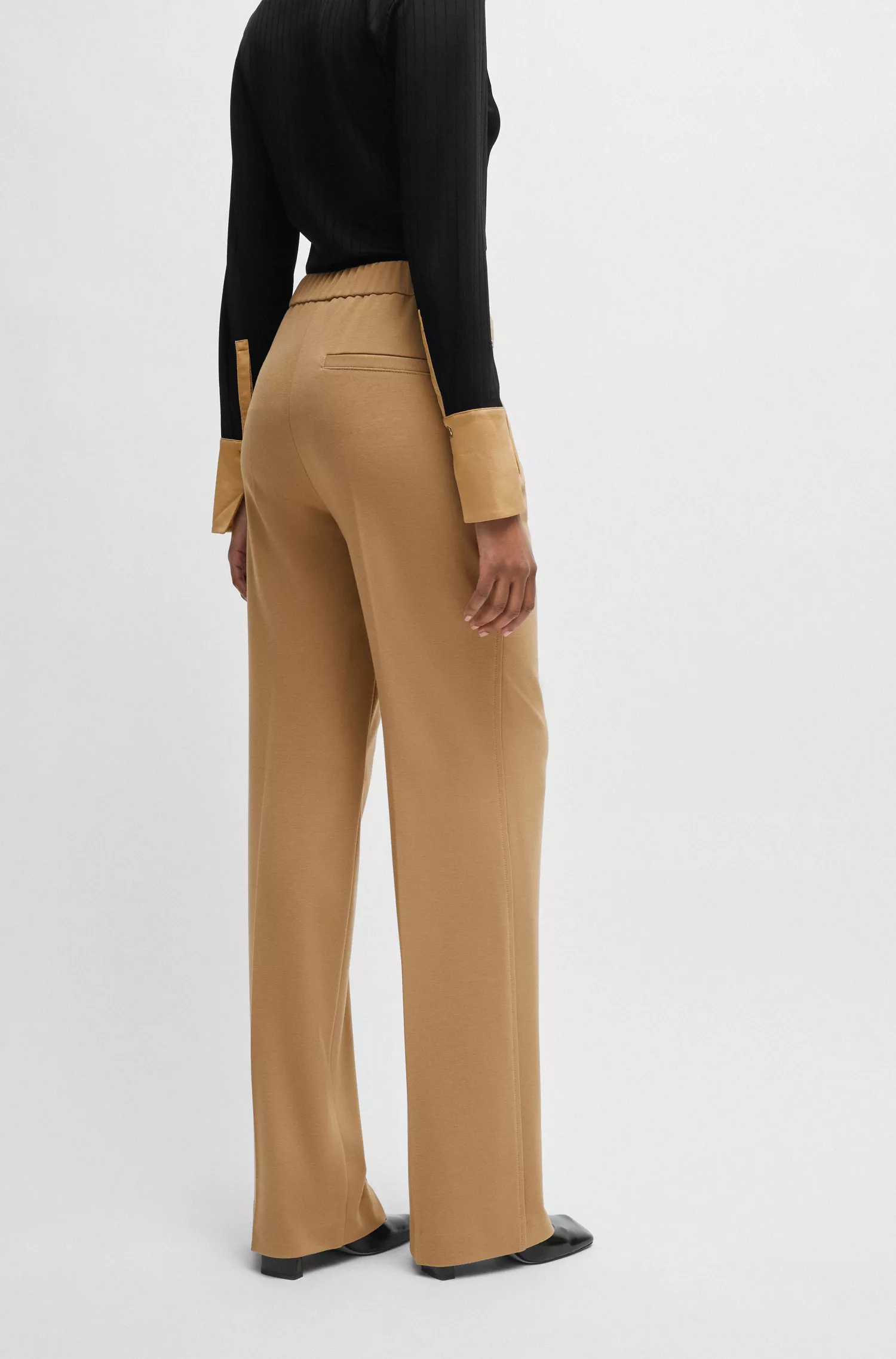 Calça BOSS preta de corte relaxado com boca de sino em tecido elástico.