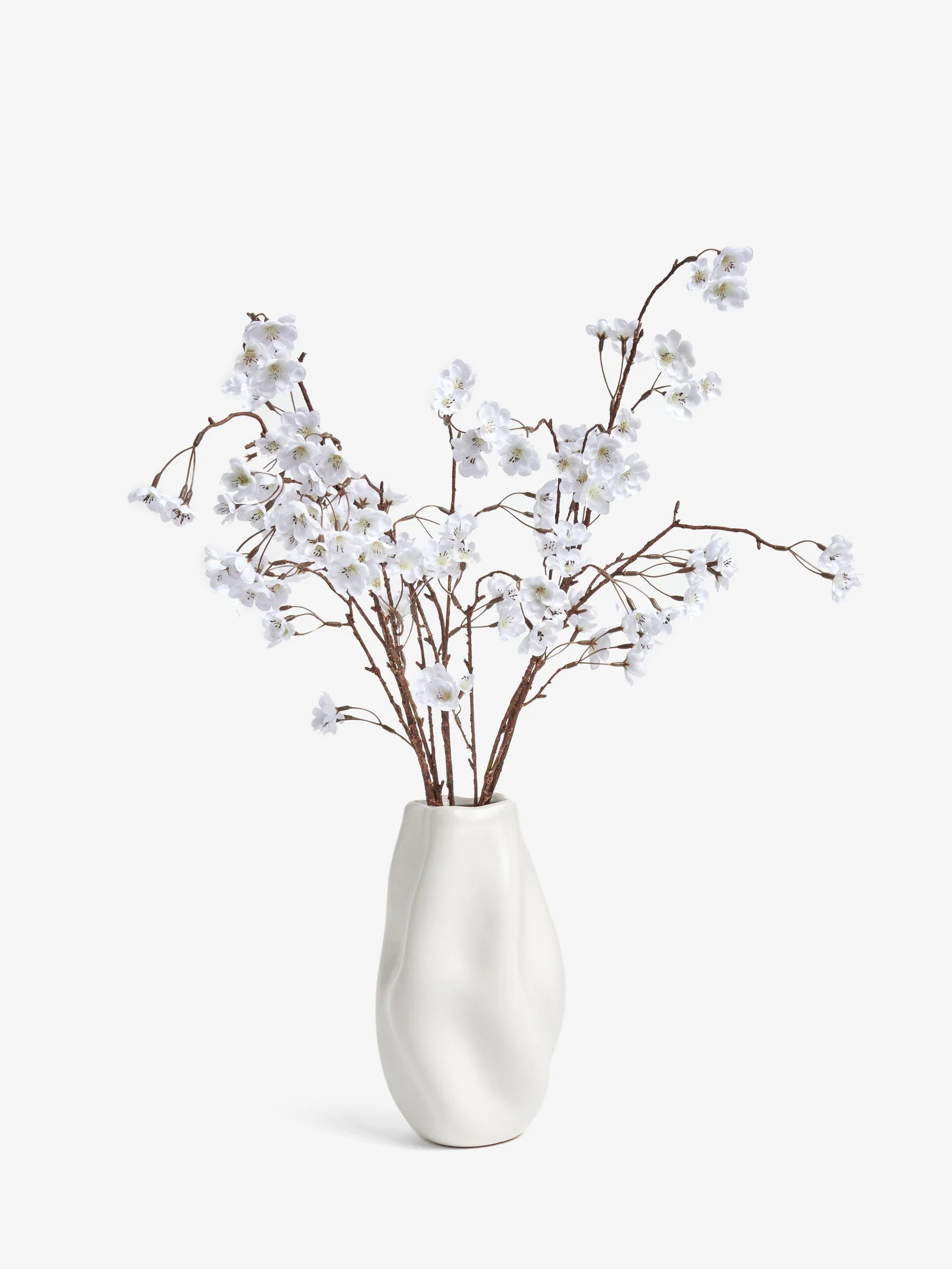 Kunstbloesemstelenarrangement in witte keramische vaas